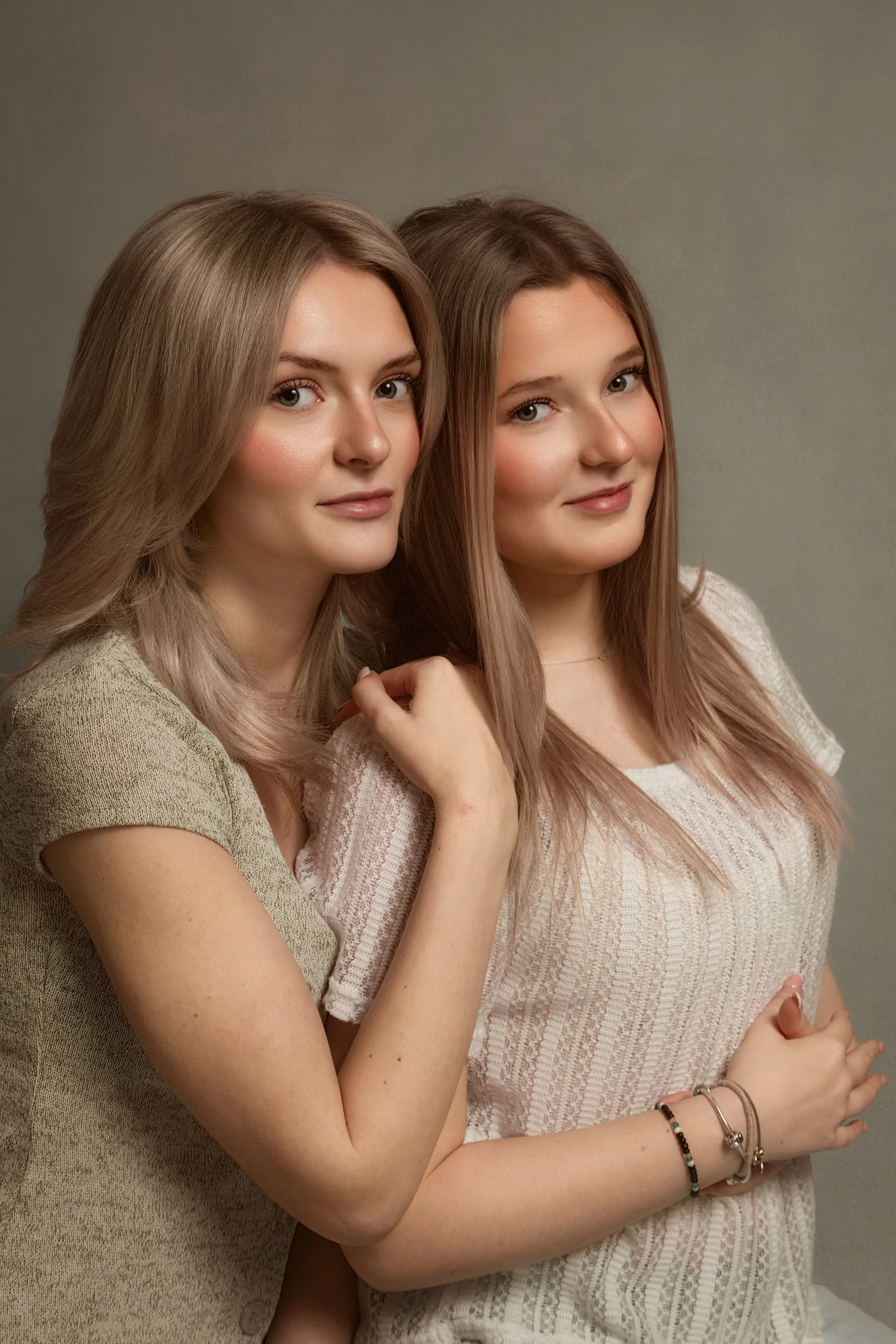 Fine art portrait of two sisters photographed in a signature studio session near Whitefield, Greater Manchester. A beautifully styled children’s portrait celebrating sisterly bond with soft lighting and a classic, heirloom-inspired aesthetic