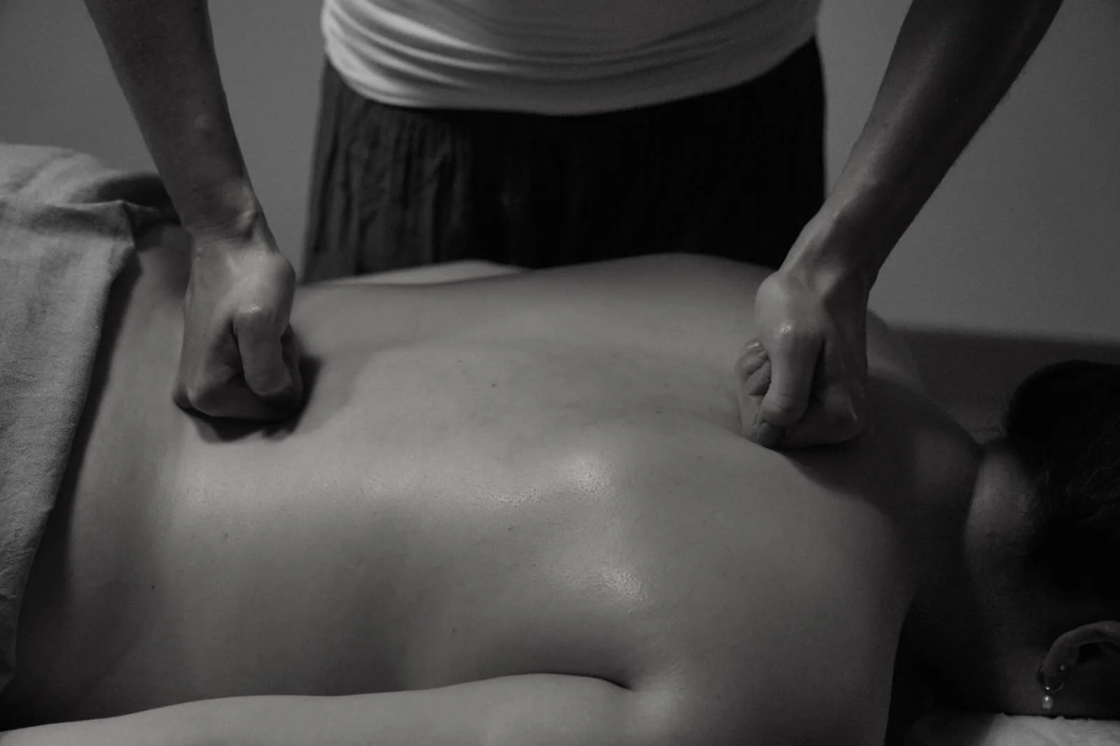 Handtuch wird auf den Rücken einer Person im Dunkeln gelegt.