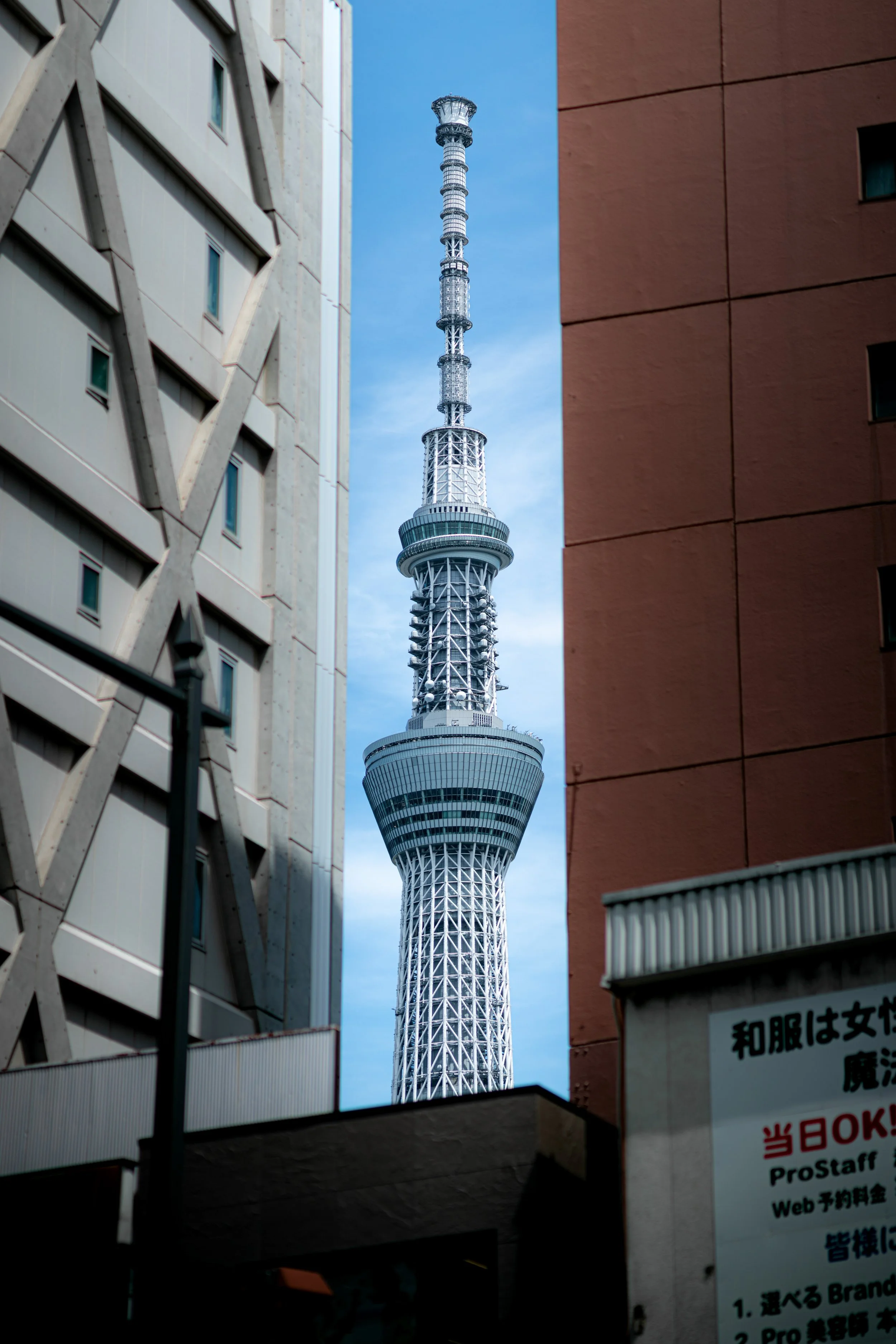 Tokyo Skytree framed between two buildings in an urban area.