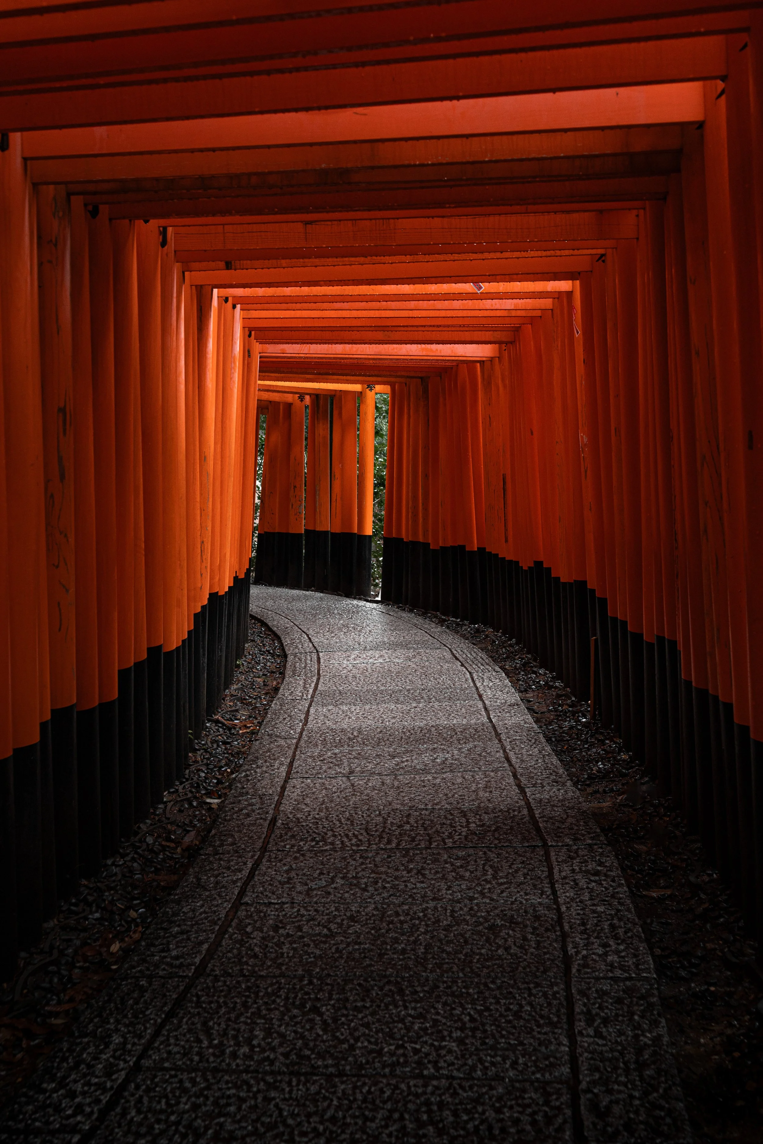 A pathway through a tunnel of orange torii gates at Fushimi Inari Shrine, Japan.