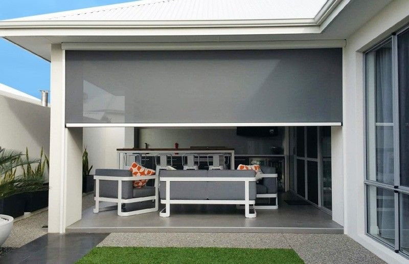 Un homme tenant une moustiquaire en verre devant une fenêtre moderne.