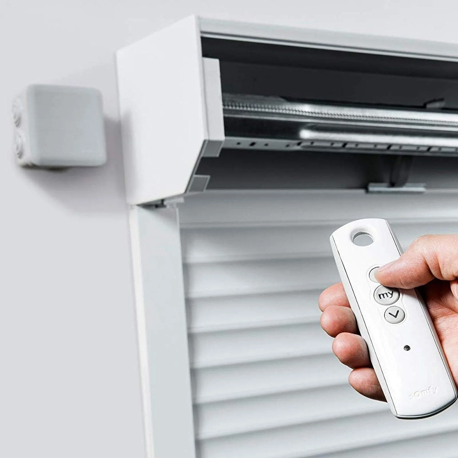 Vue au ras du sol d'une porte moustiquaire en métal avec un sol en marbre, à l'extérieur on voit des arbres verts et un ciel bleu.