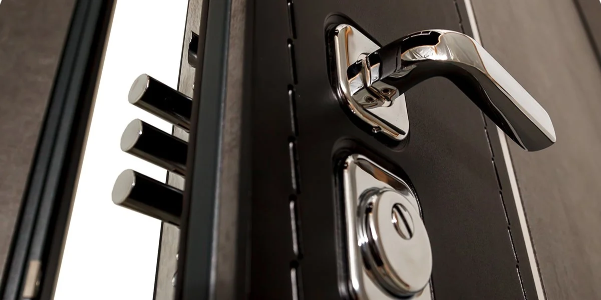 Prise électrique et verrou de serrure sur une porte en métal.