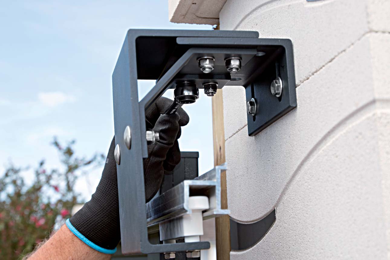 Un travailleur en train d'installer ou de réparer un panneau solaire en utilisant une perceuse ou un outil électrique.