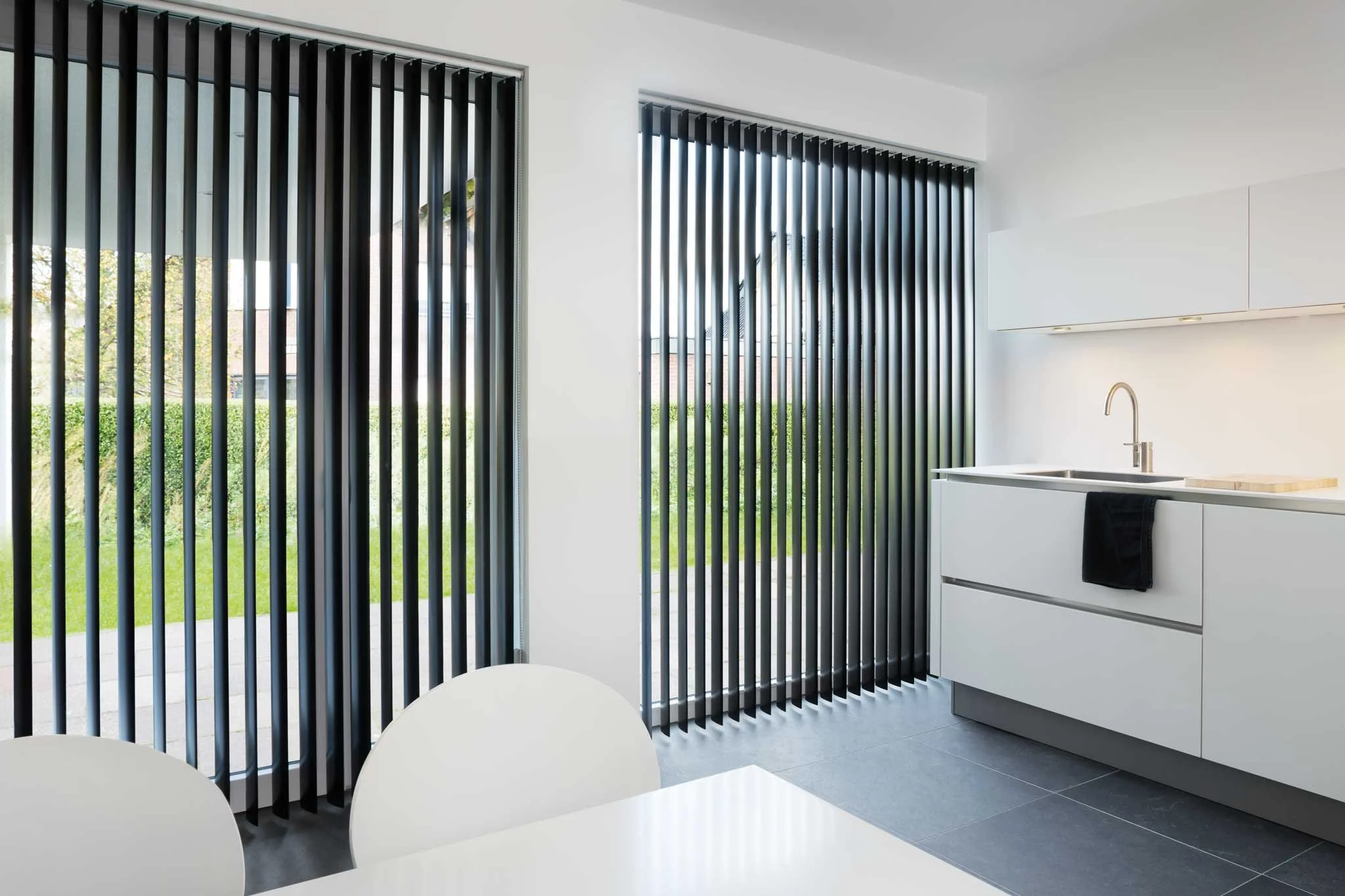 Un homme tenant une moustiquaire en verre devant une fenêtre moderne.