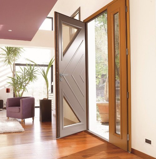 Un homme tenant une moustiquaire en verre devant une fenêtre moderne.