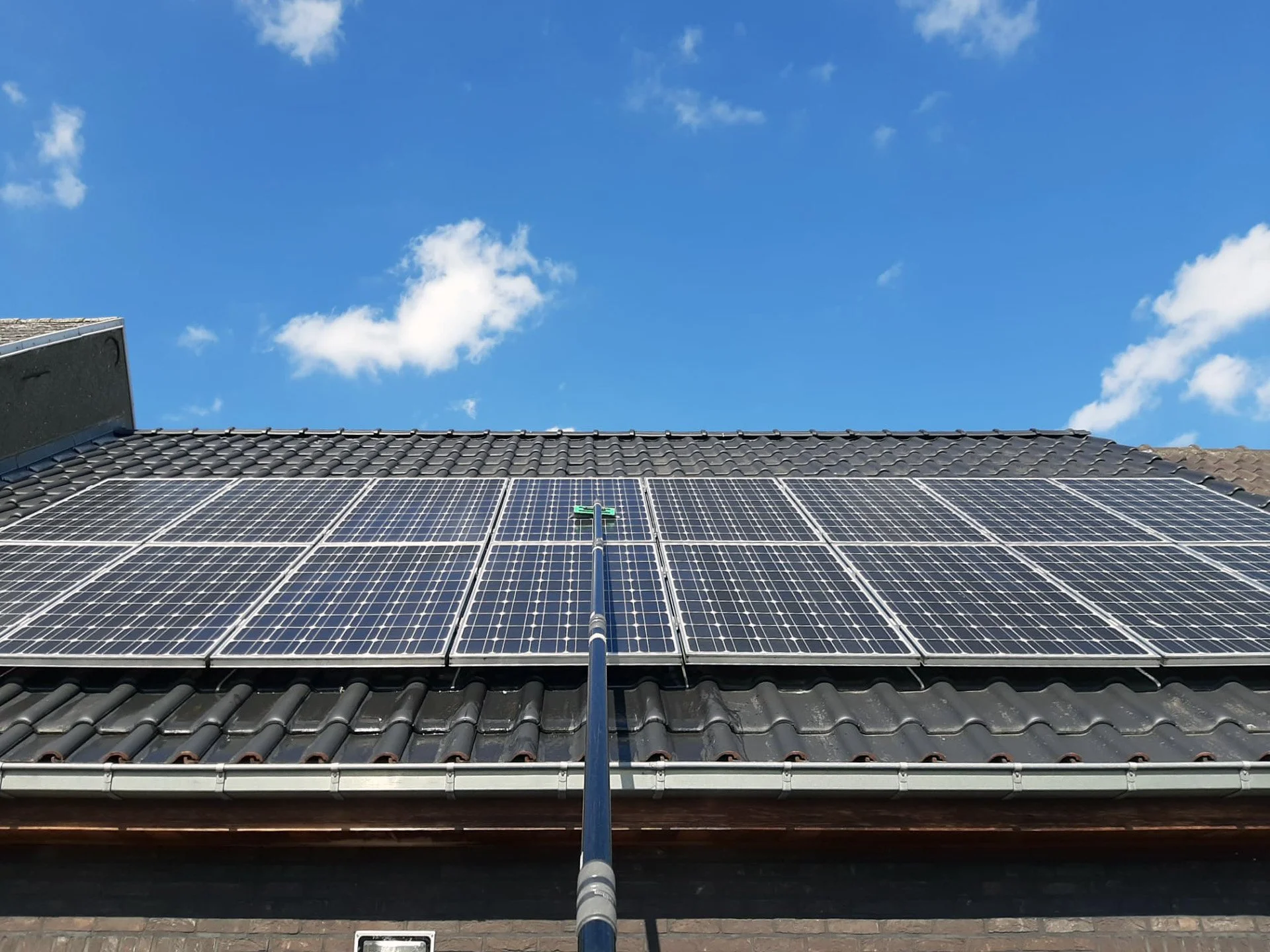 Dak met zonnepanelen wordt gereinigd door middel reinigingsrol en osmose.