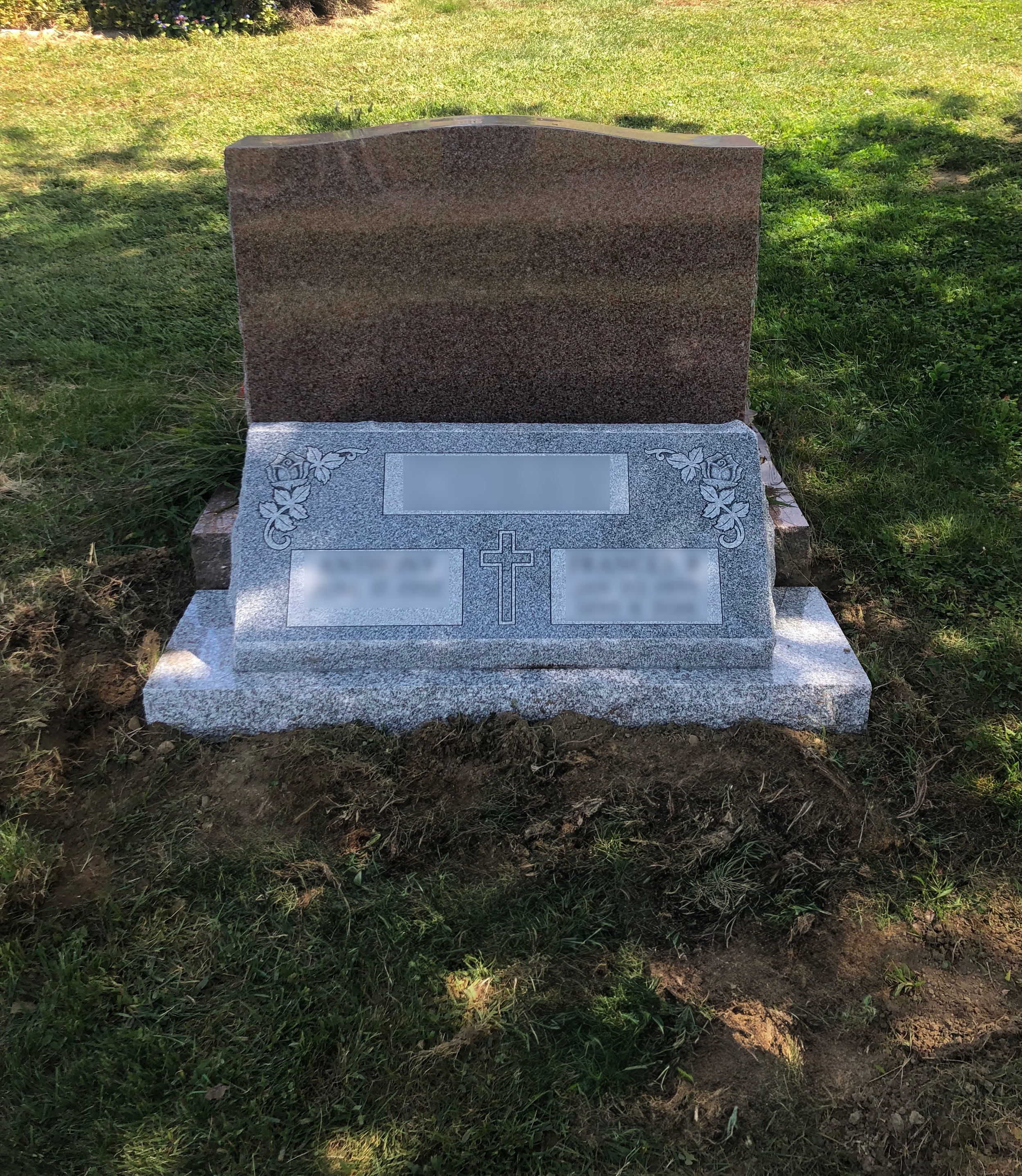 Upright granite monument with sloped or pillowed monument style, with personalized engraving and decorative carving.
