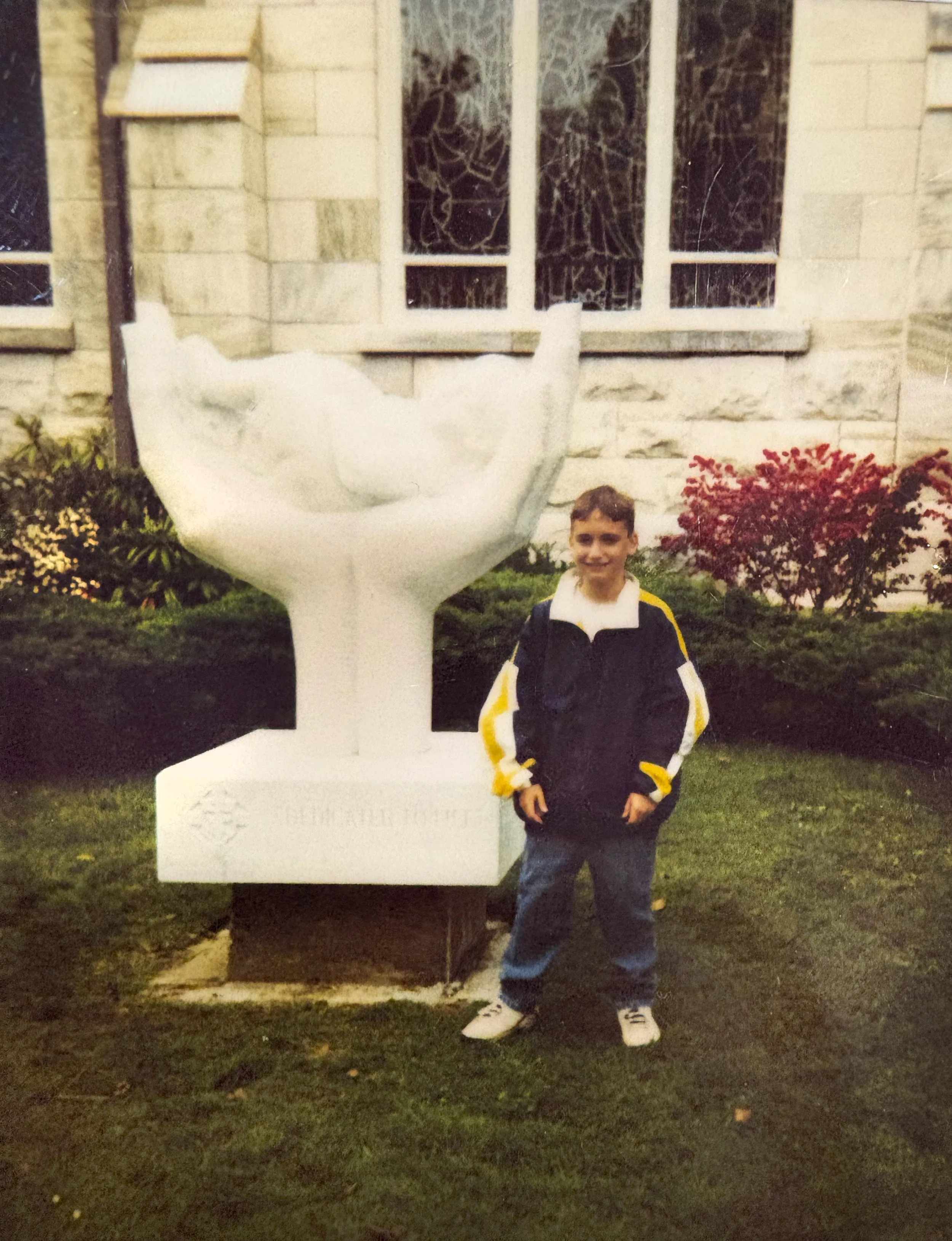 Young Rob Barelli, owner of Leo’s Monuments and Floral Co., next to a memorial that his father’s Monument business crafted.