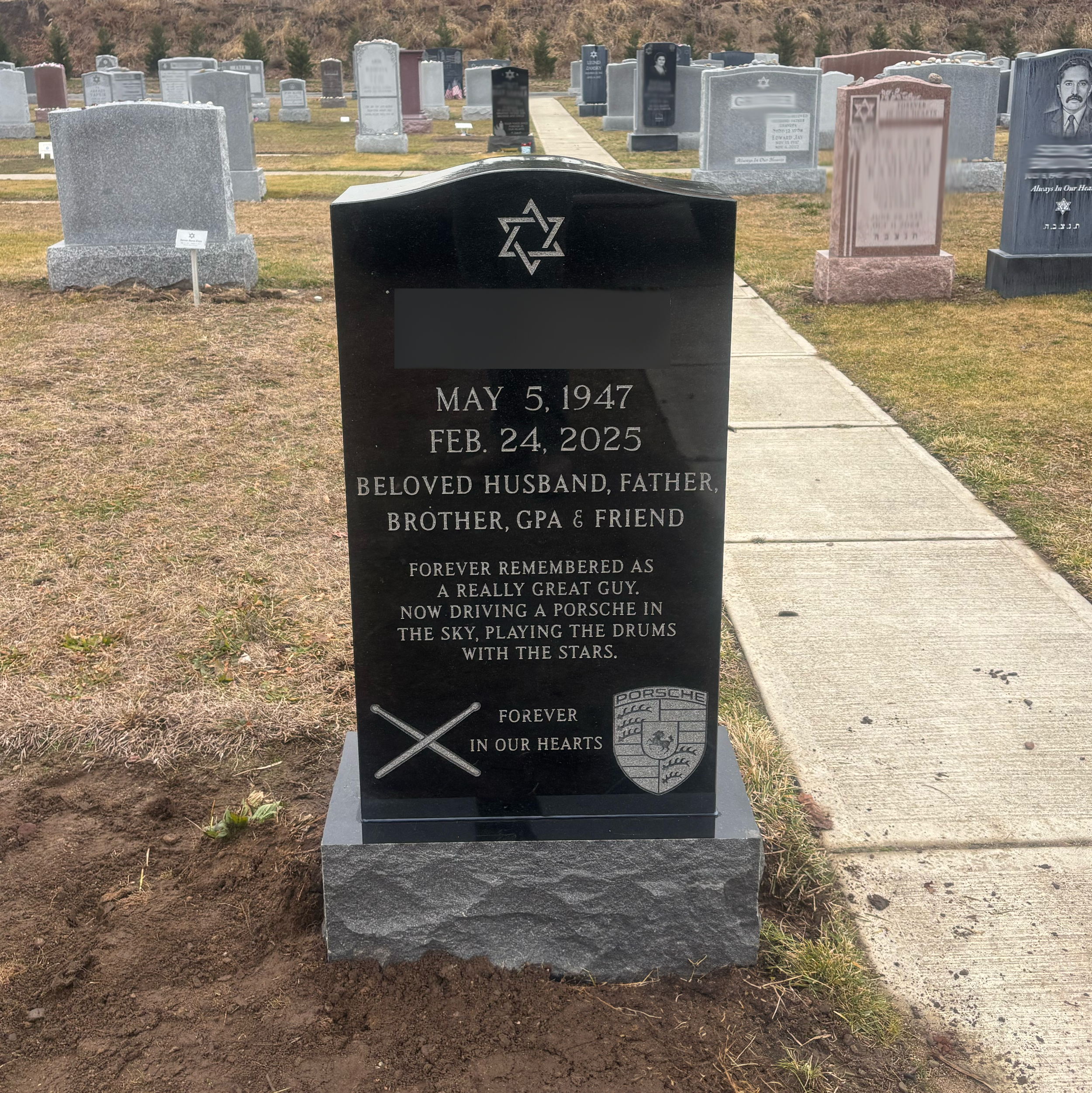 Upright granite monument with personalized engraving, decorative carving, and religious detail.