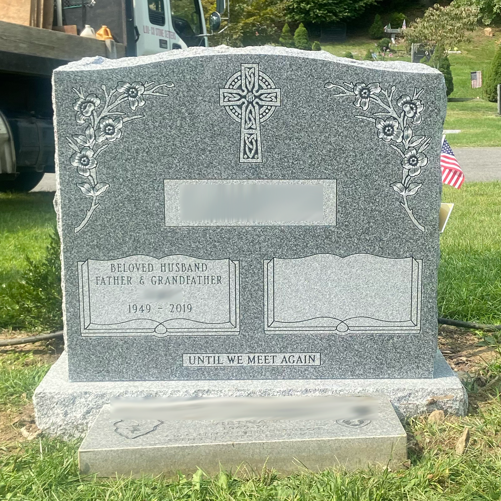 Upright double granite monument with personalized engraving, decorative carving, and religious detail.