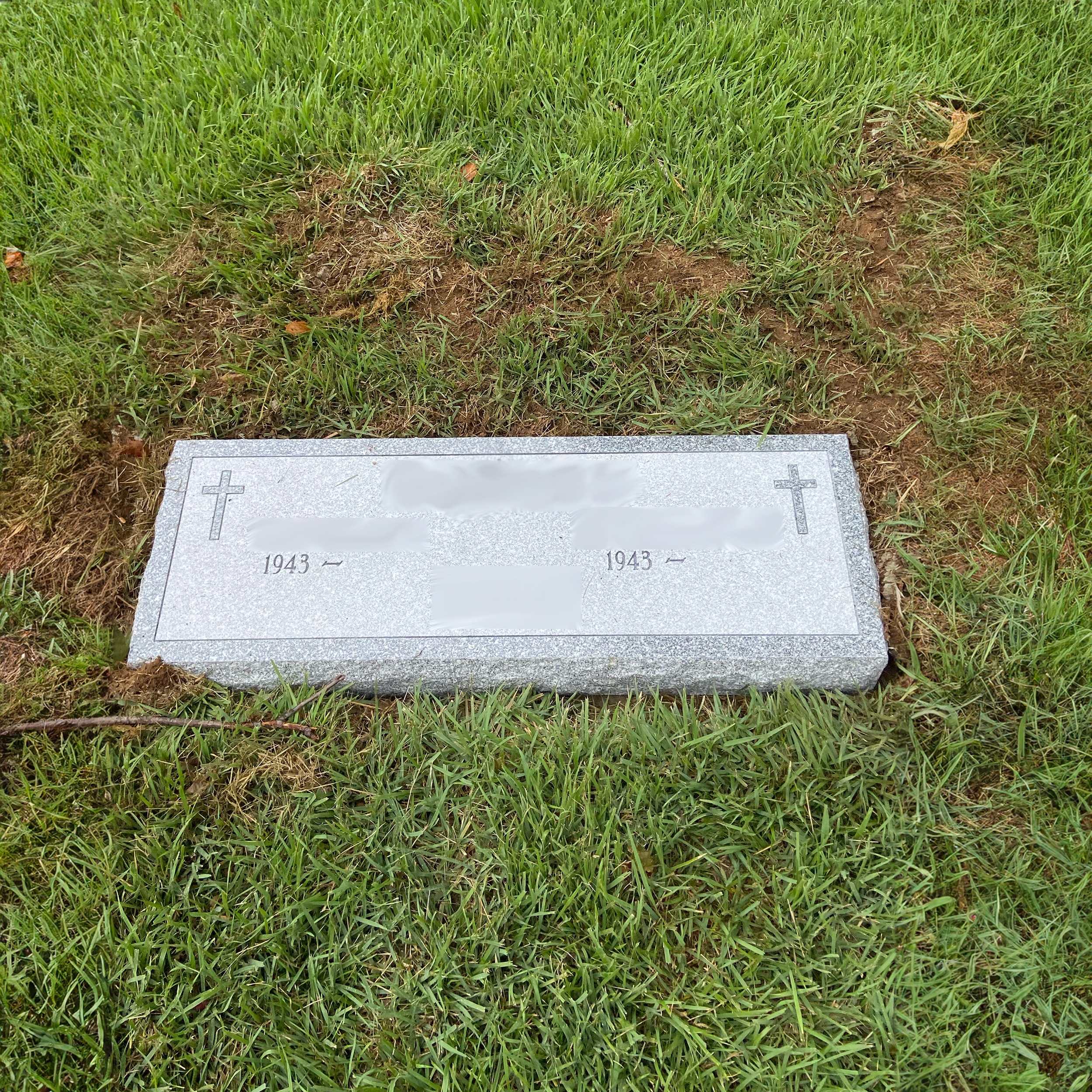 Flat granite grave marker with custom inscription for a cemetery memorial.