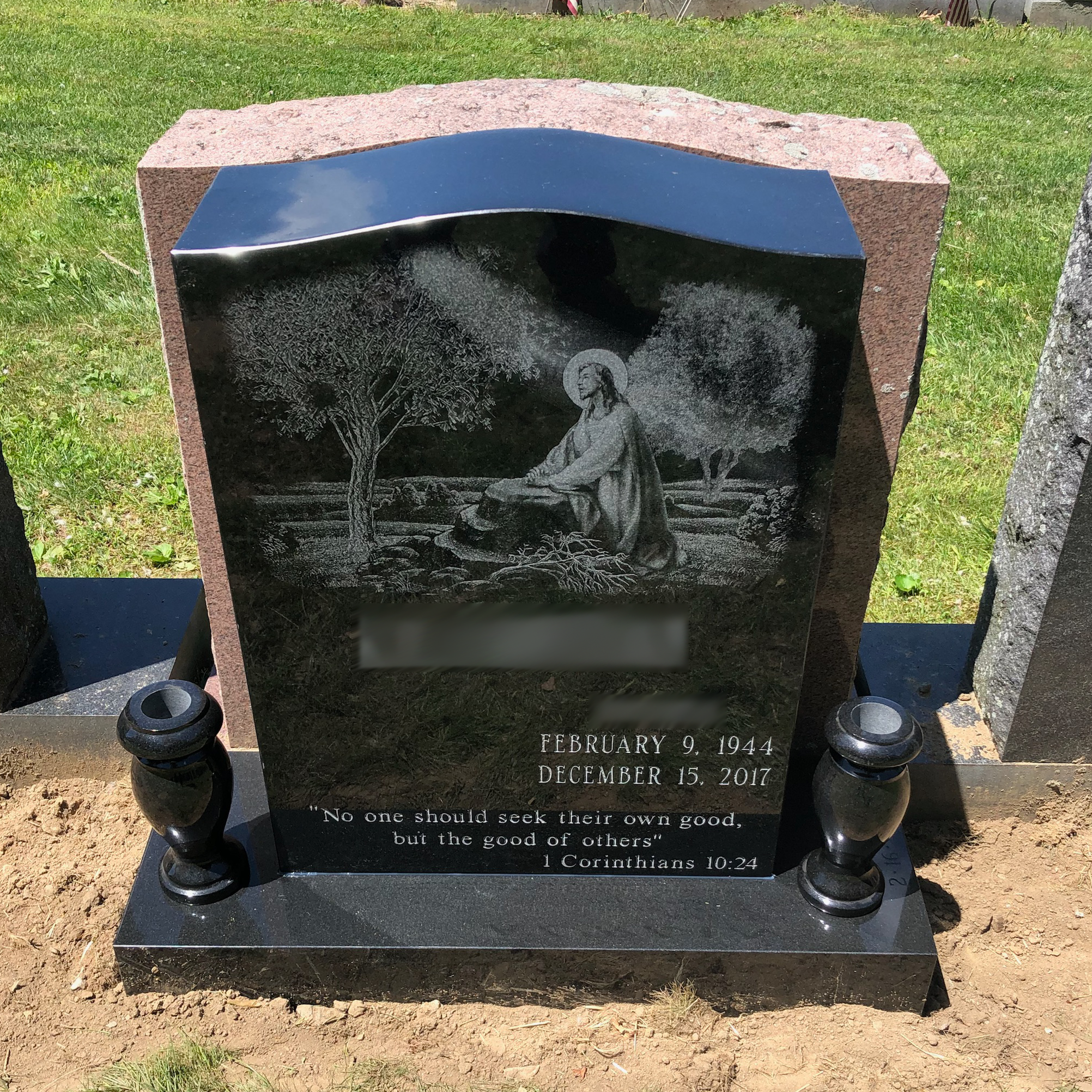 Upright granite monument with personalized engraving, decorative carving, and religious detail.