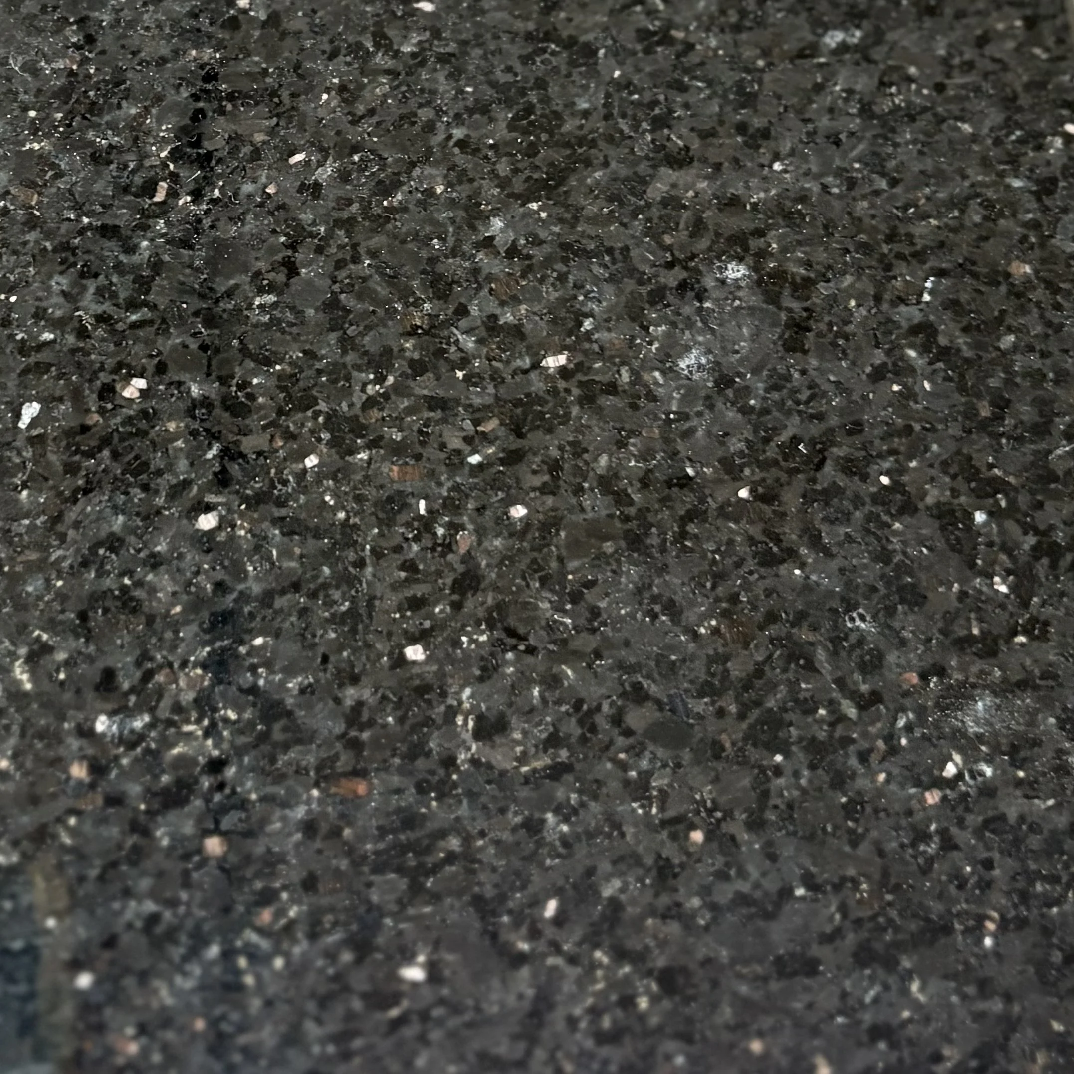 Close-up view of Impala, a black speckled granite with a polished surface.