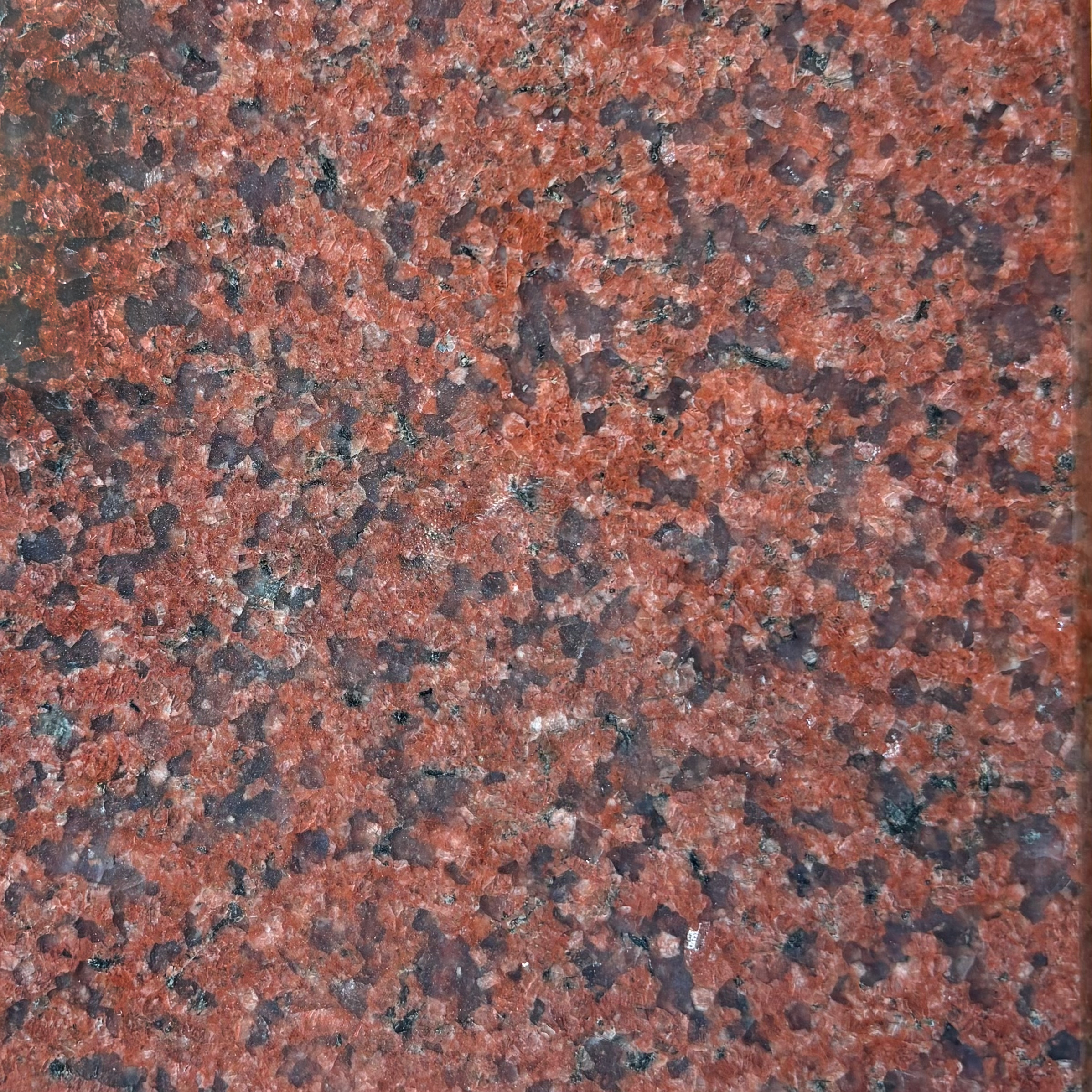 Close-up of Indian Red granite, a red and black speckled polished granite.