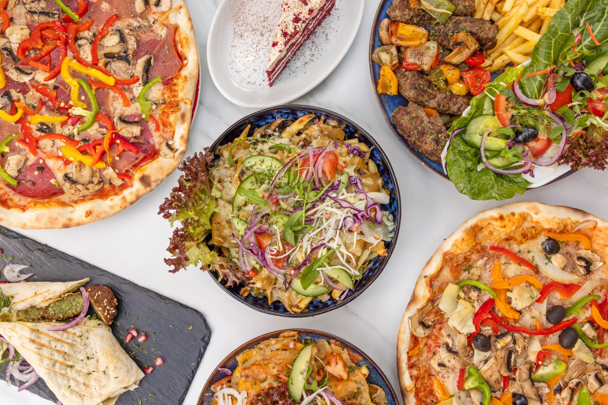 Gerechten van De Serre van Cleopatra in Wageningen: pizza, vegan kebab, falafel en verse salades.