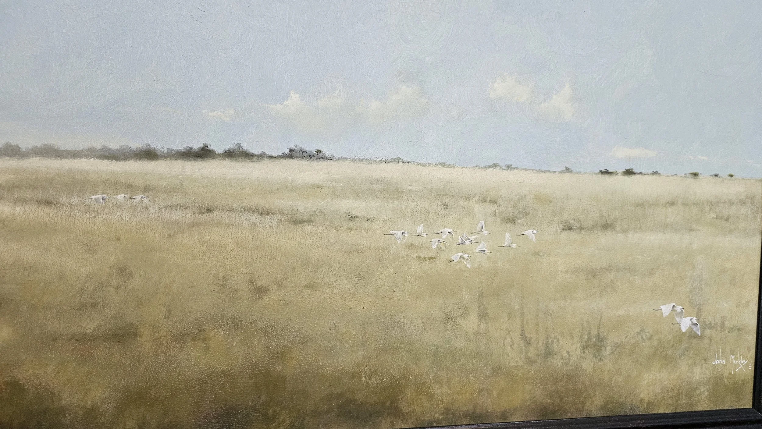 Painting of a grassy field with a flock of white birds flying, under a blue sky with a few clouds.