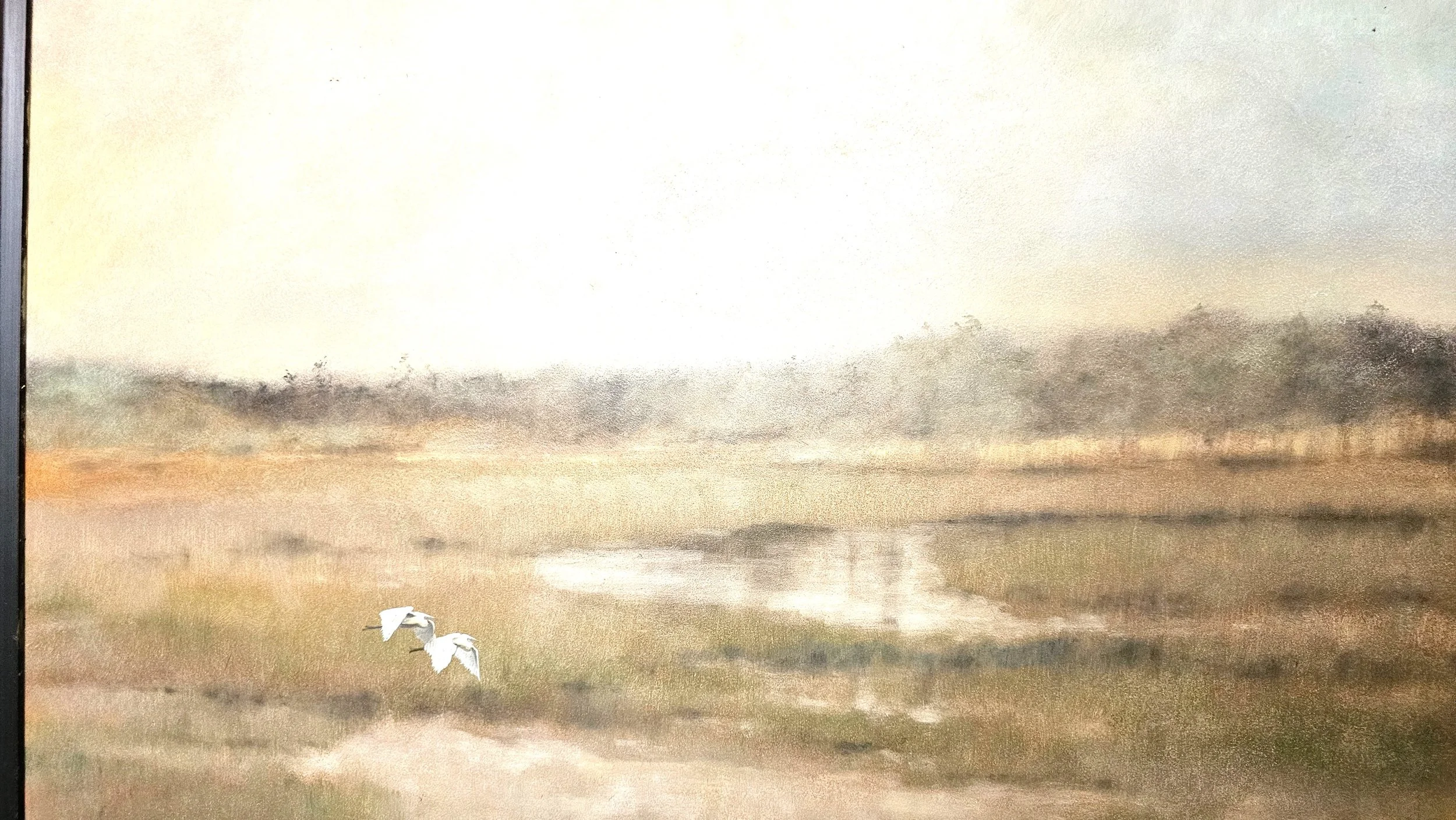 A watercolor painting of a landscape with a dirt path, a water body, green grass, and trees in the background. Two white birds are flying over the grass near the water.