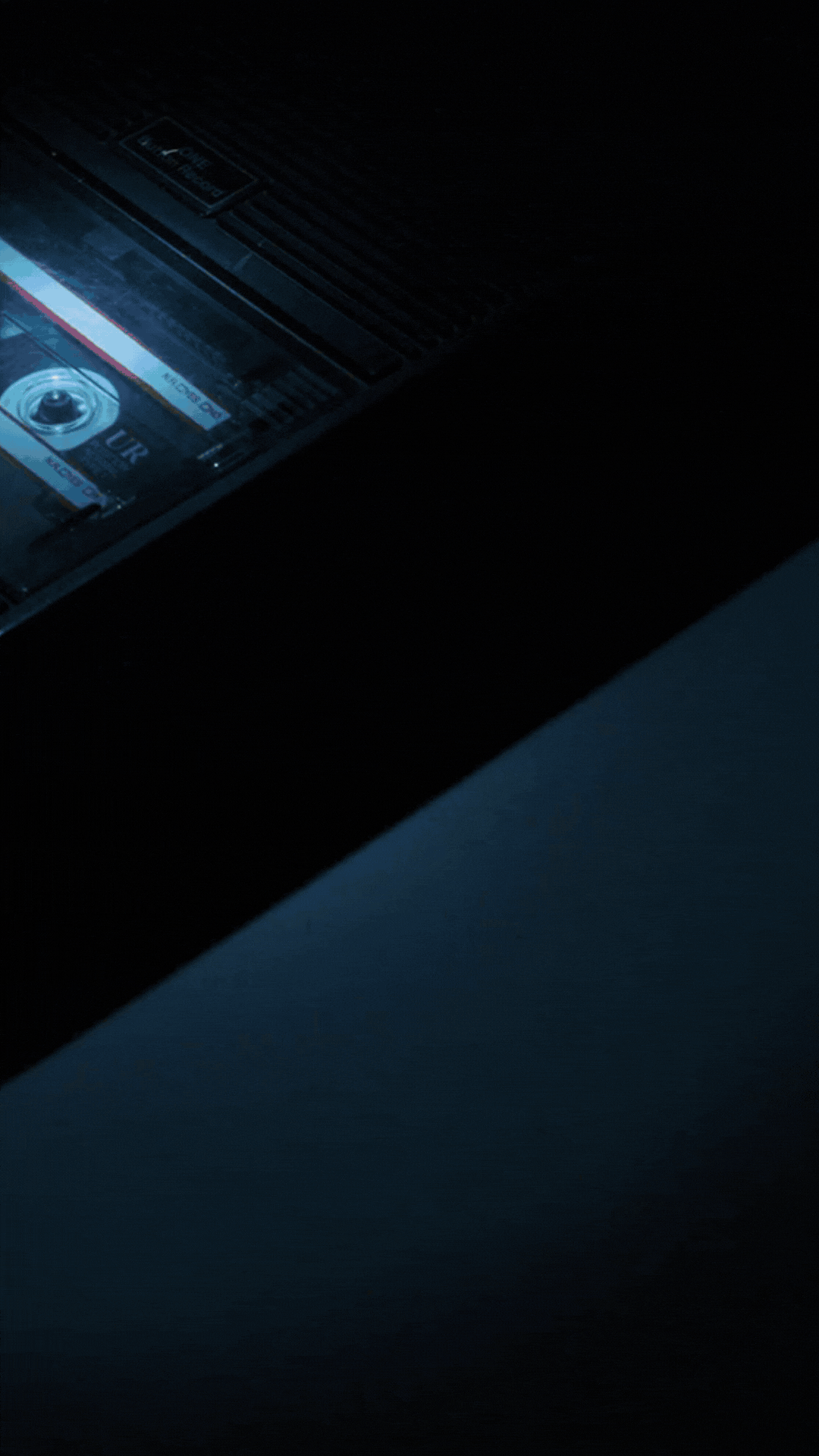 Close-up of a computer motherboard with visible RAM slots and a cooling fan in a dimly lit environment.