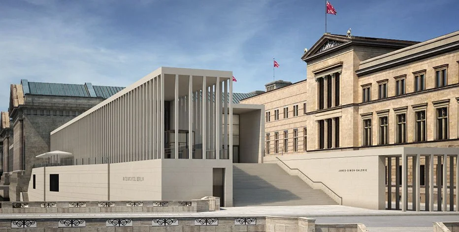 Modernes weißes Museumsgebäude mit Säulen vor historischer Regierungsgebäude in Berlin.