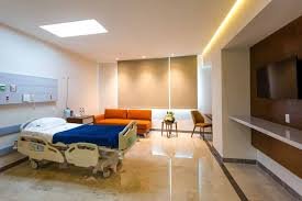 Modern private hospital room with adjustable bed, seating area, and clean, upscale medical environment.
