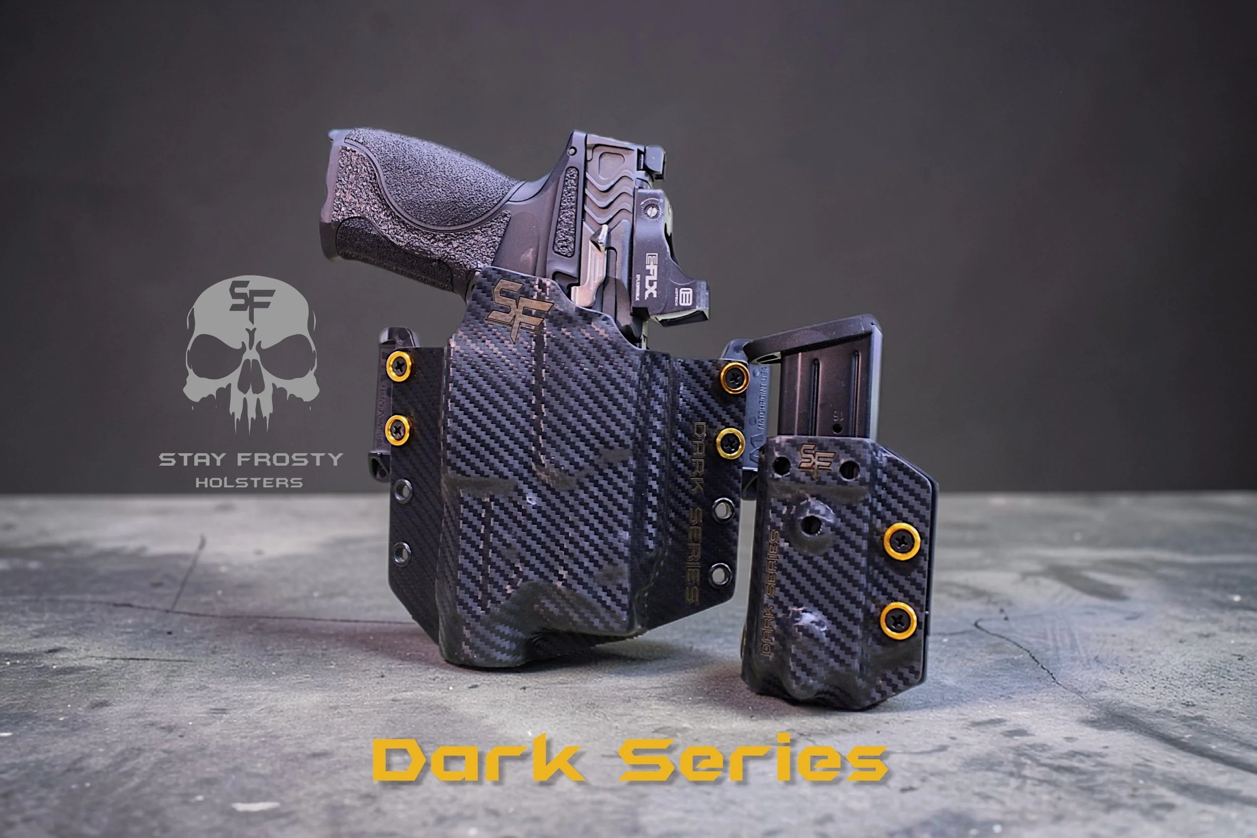 A black semi-automatic handgun with textured grip, mounted inside a black carbon fiber holster with gold screws. The holster and additional magazine holder are also made of carbon fiber with gold accents, positioned on a concrete surface against a dark background. The image features the logo and text 'Stay Frosty Holsters' on the left and 'Dark Series' in yellow at the bottom.