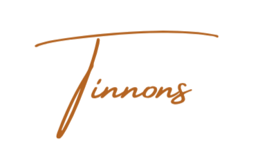 The logo of Tinnnang with stylized brown text on a black background reading "Tinnnang."