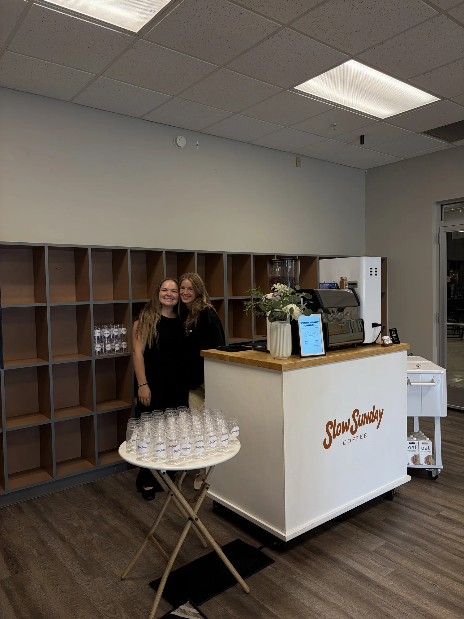Two Slow Sunday baristas at the coffee cart set up indoors