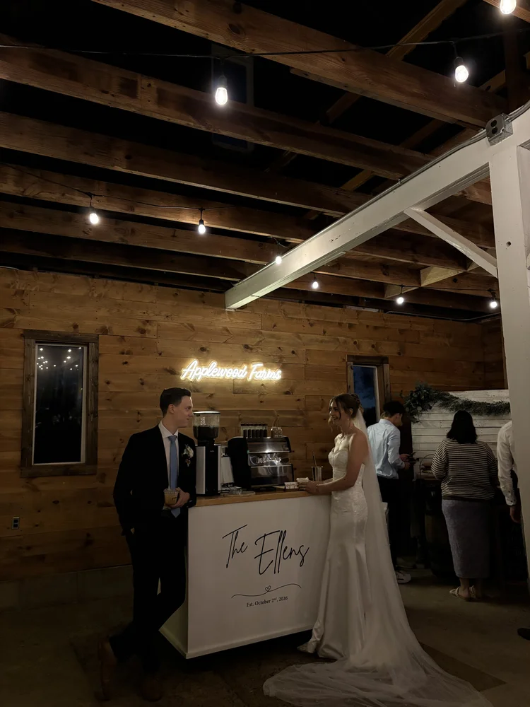 Bride and groom beside the Slow Sunday coffee cart in a barn venue
