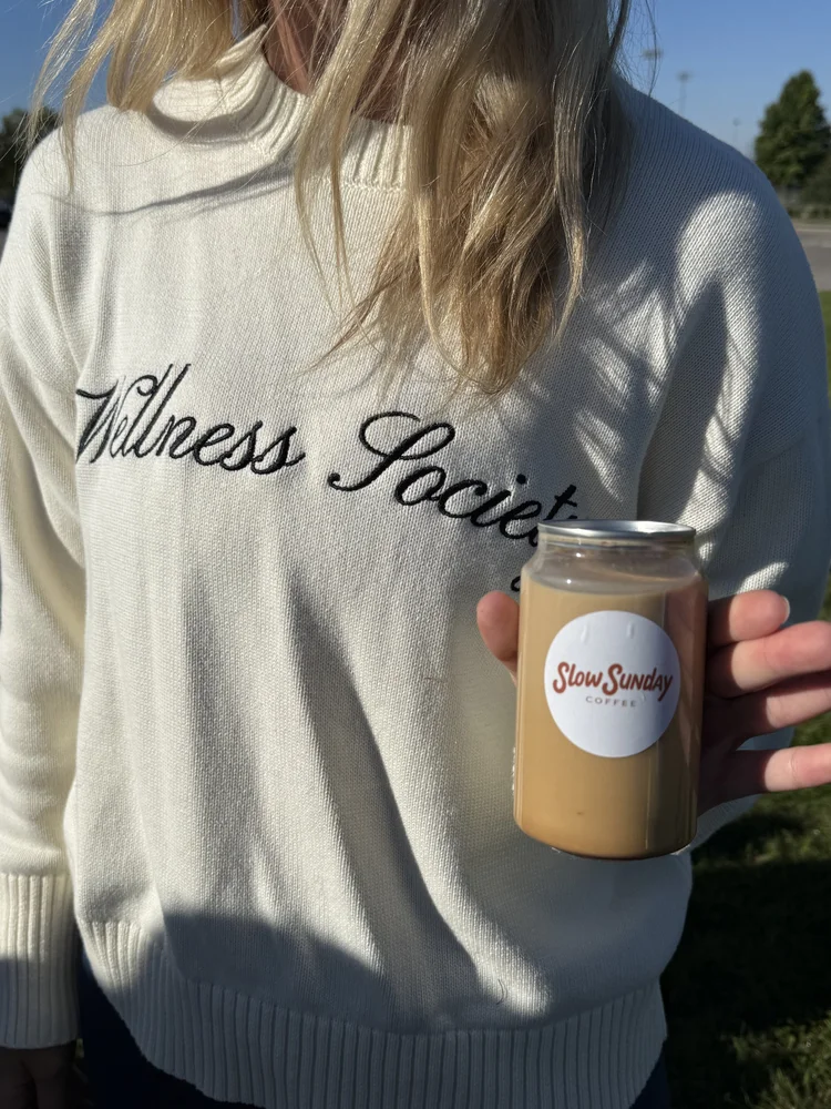 Guest holding an iced coffee with a Slow Sunday sticker