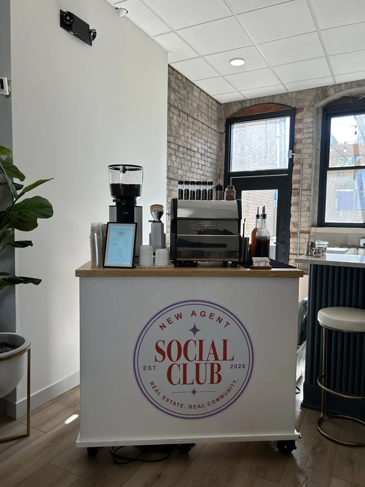 Branded coffee cart in a brick loft office with a barista behind it