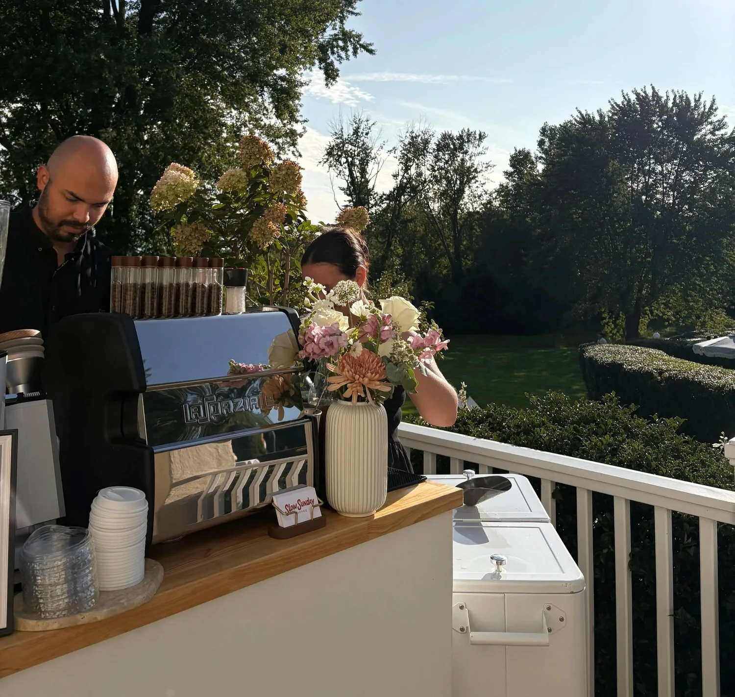 Coffee cart serving guests outdoors on a deck at an evening event