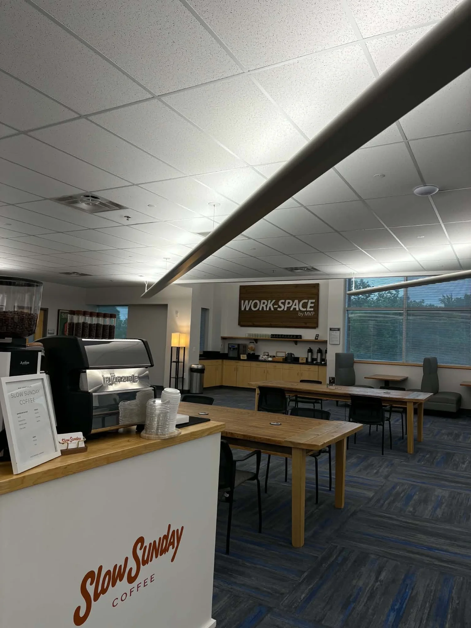 Coffee cart set up inside a bright office with wooden tables for a corporate event
