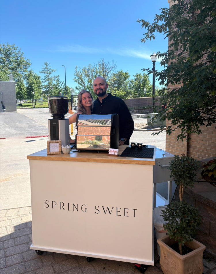 Barista behind a branded coffee cart at an outdoor brand activation