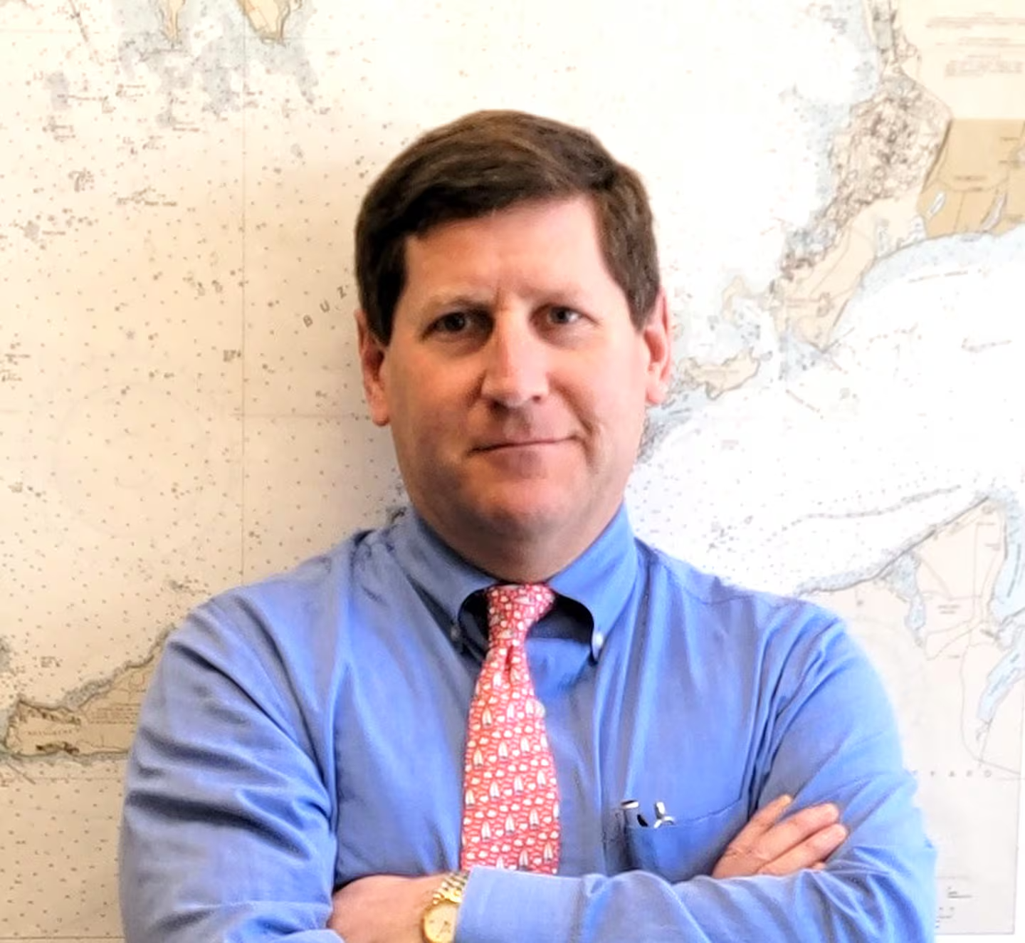 David Traub in a blue shirt with a salmon tie and his arms crossed