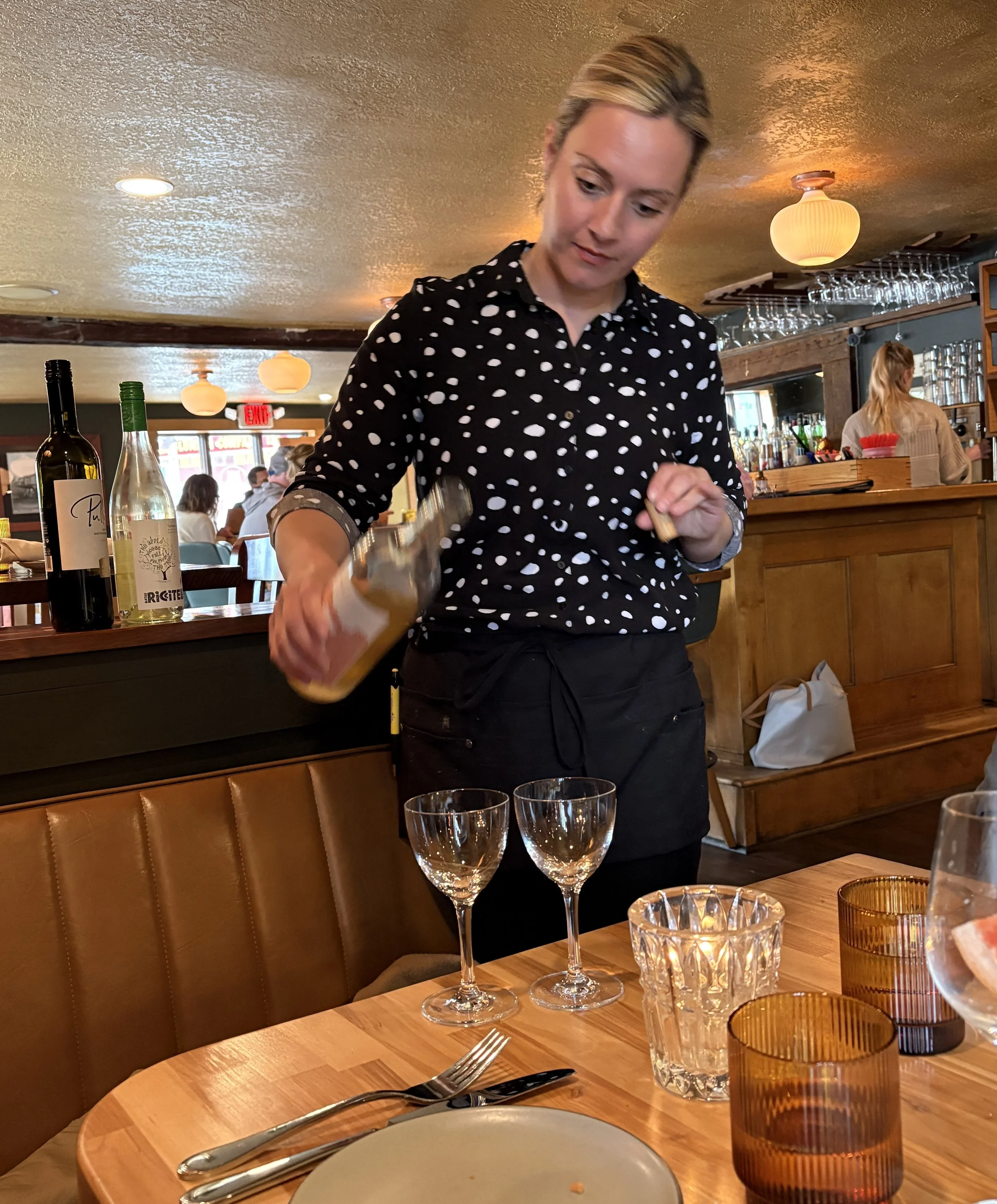 Server at Sentinel & Station in Lake Placid serving wine,