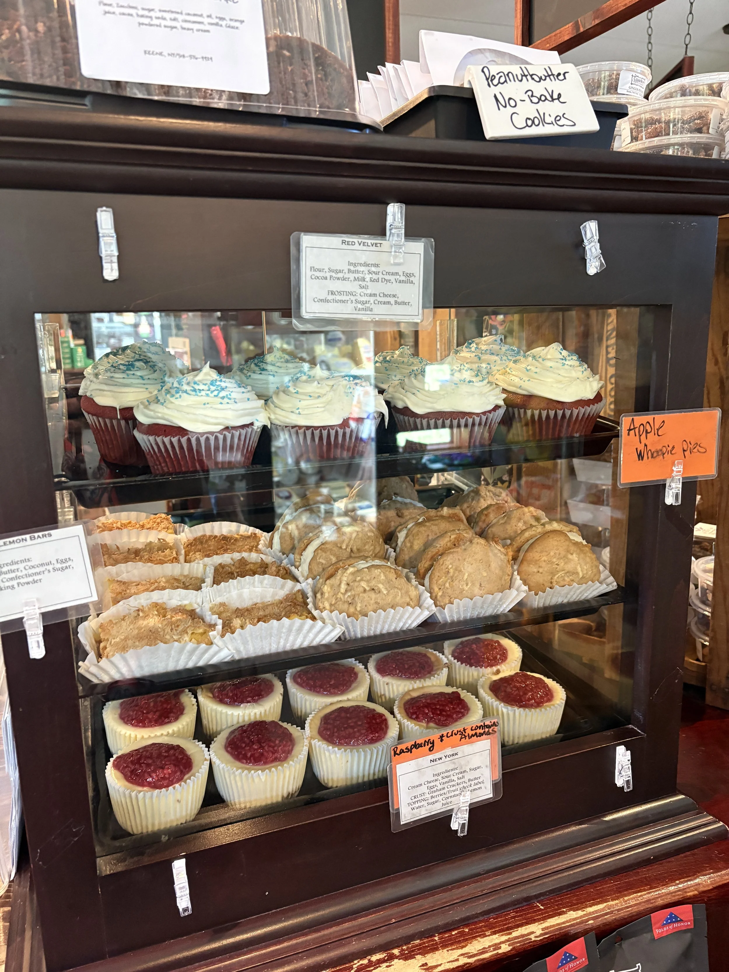 A wood case filled with cupcakes, cheesecakes, and cookies at Cedar Run Bakery in Keene, NY.