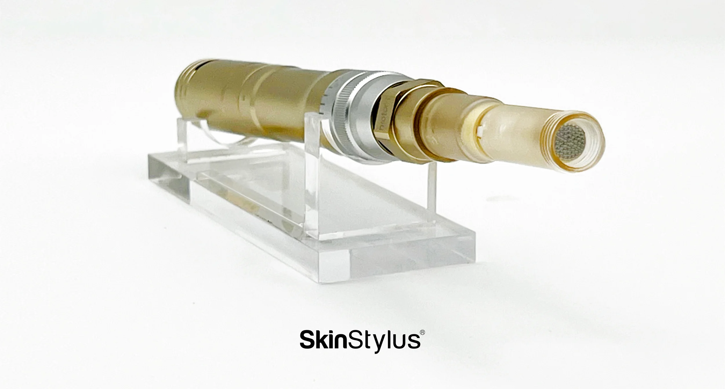 A SkinStylus cosmetic tool with a beige, silver, and gold body, displayed on a clear stand used at Beyond Facials Santa Monica for nano facial