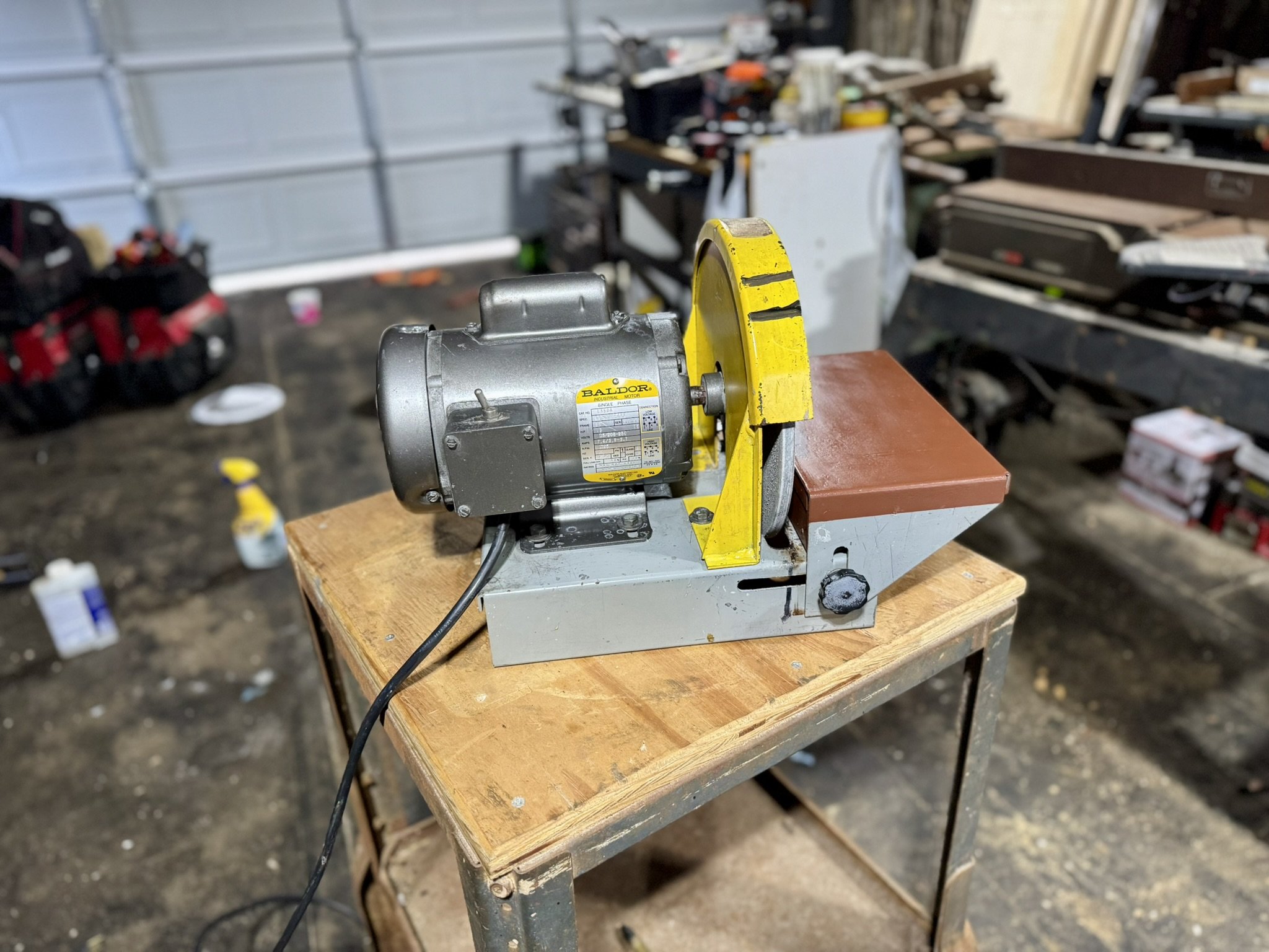 Kalamazoo Industries 10-inch disc sander with a gray Baldor industrial motor sitting on a shop workbench.