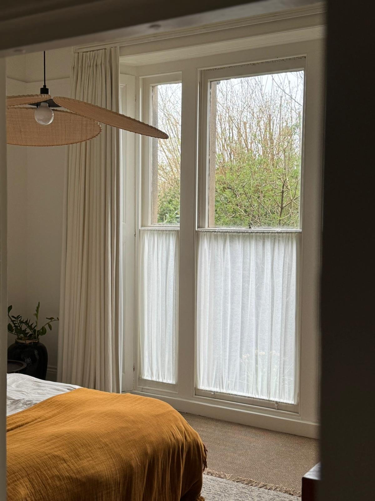 Double pinch pleat linen curtains paired with a double rod, gathered café curtain in Ivory linen sheer