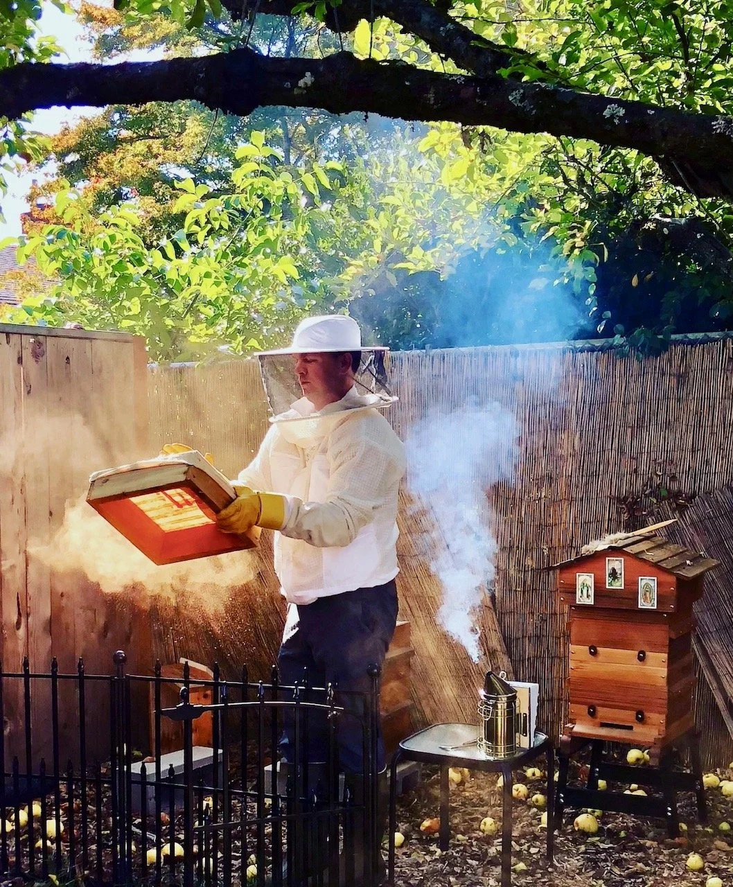 Asher Bar-Nes Caldwell, PMHNP, tending one of his beehives—an expression of the patience, attentiveness, and stewardship that also guide his approach to psychiatric care.