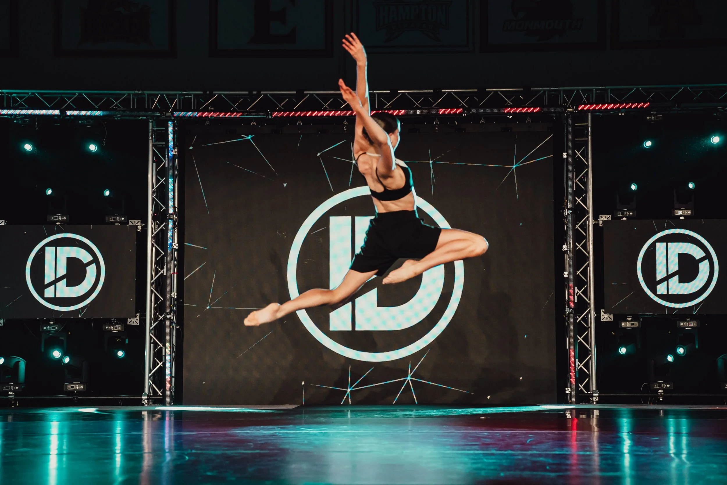 Dancer jumping in front of logo for ID Dance company