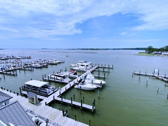 Marina with docked boats on a calm body of water under a partly cloudy sky.