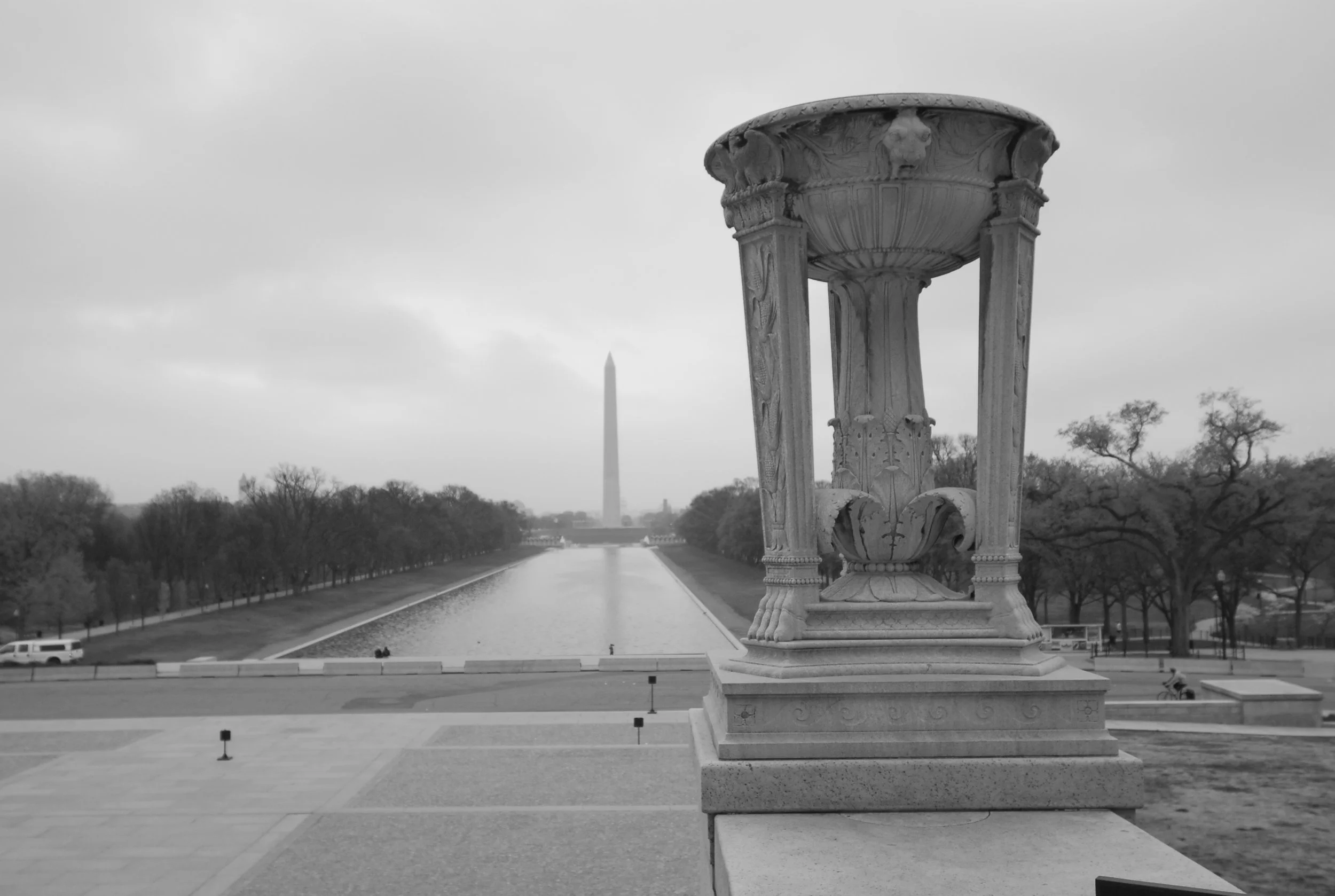 Black and white photo of the Lincoln Memorial Reflecting Pool with the Washington Monument in the distance, seen from the steps of the memorial.
