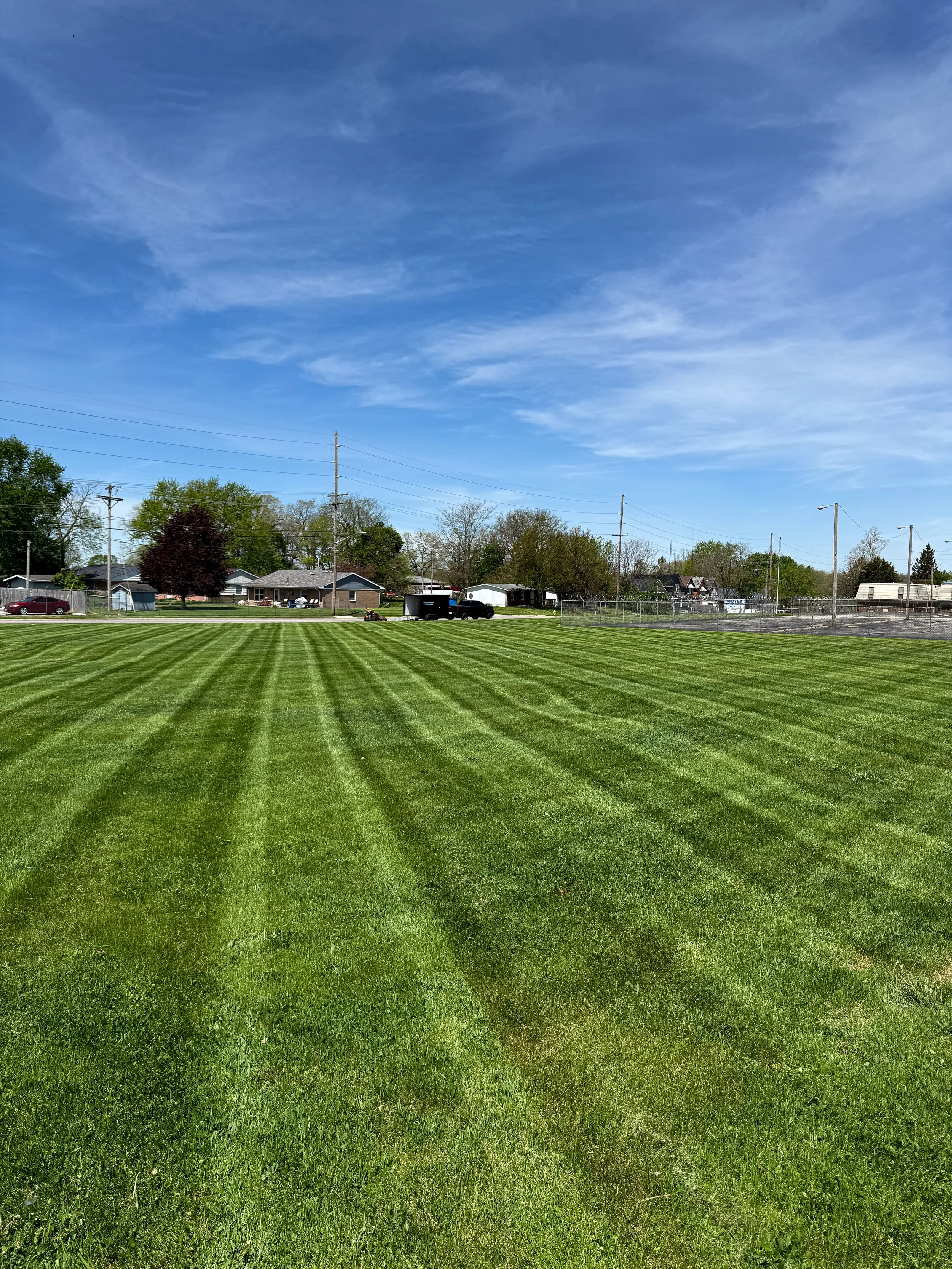 Professional lawn mowing with clean striping lines in Richmond Indiana by Maintenance Bros