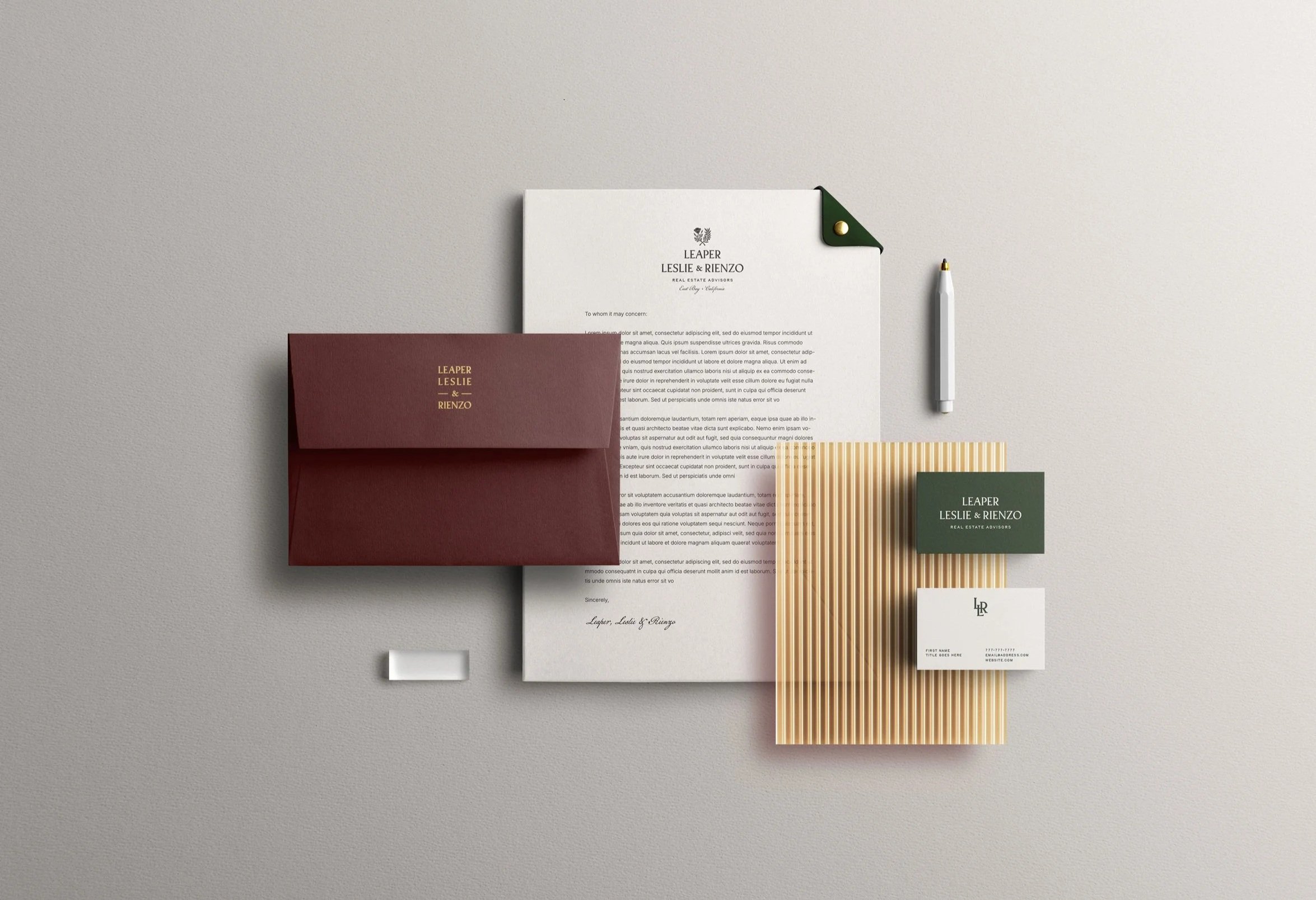 Flat lay of various branded business stationery including envelopes, business cards, letterhead, and paper with a minimalist design and neutral colors.