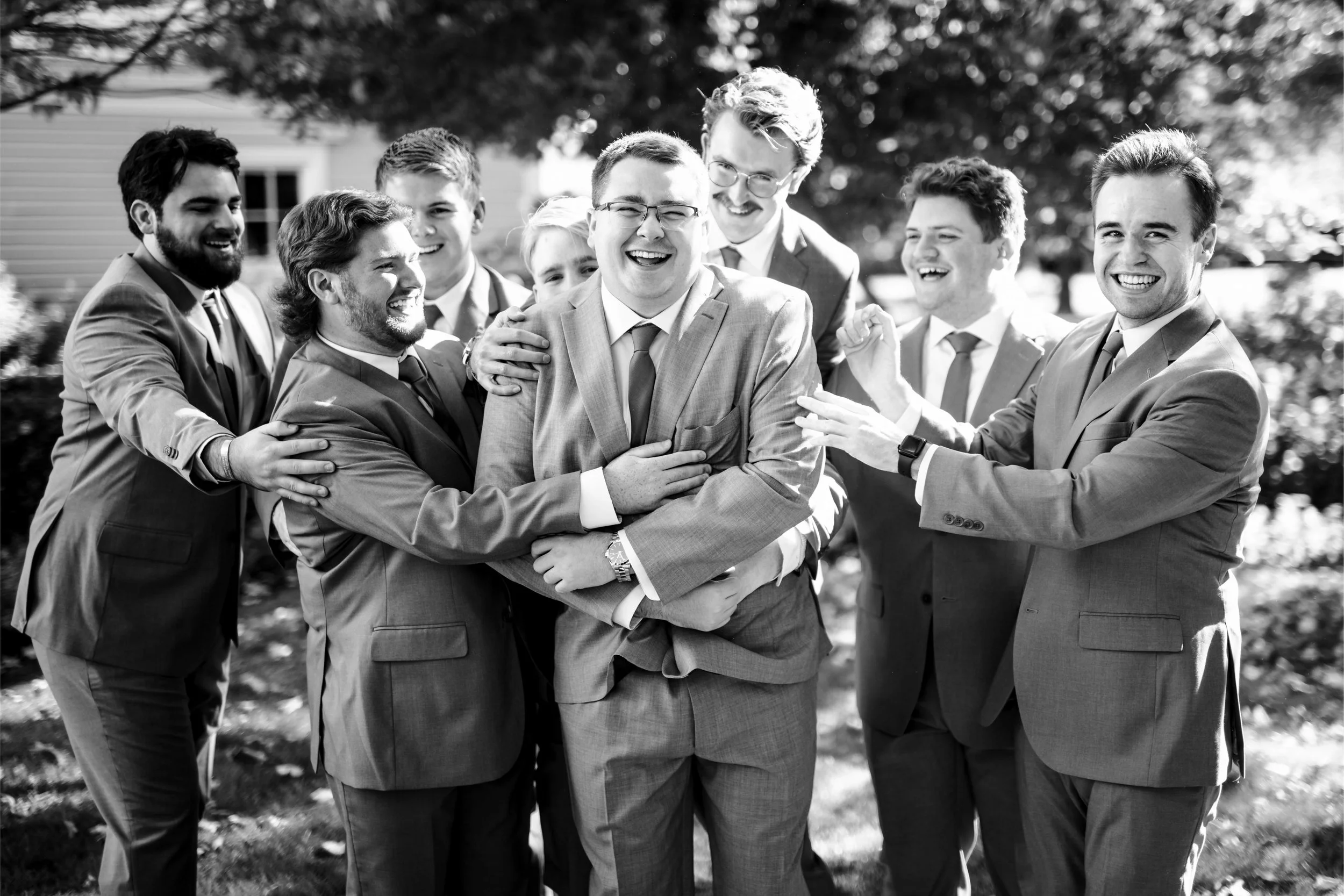 Groom and groomsmen in suits, laughing with each other, The Barn at Walnut Hill Maine, fall wedding florals by Milkweed Floral Co