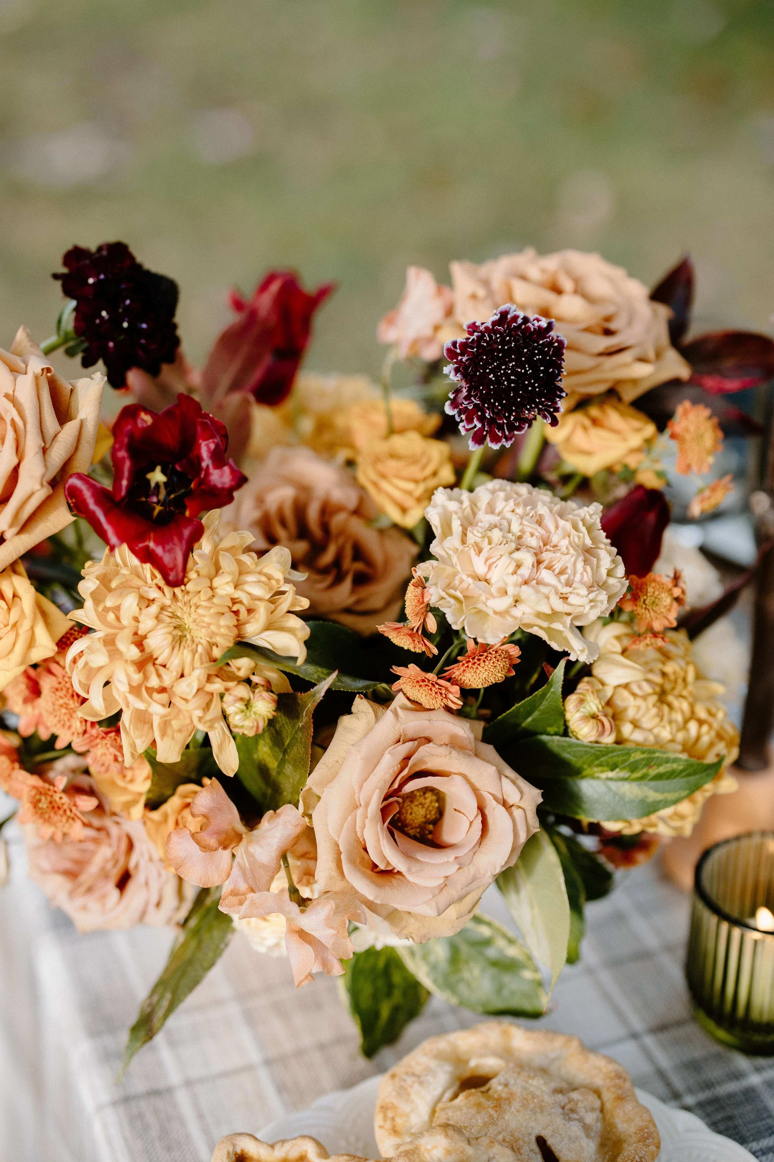 Lush fall wedding centerpiece with toffee garden roses, burgundy tulips, dark scabiosa, peach dahlias, and carnations in warm autumn tones, New England wedding by Milkweed Floral Co
