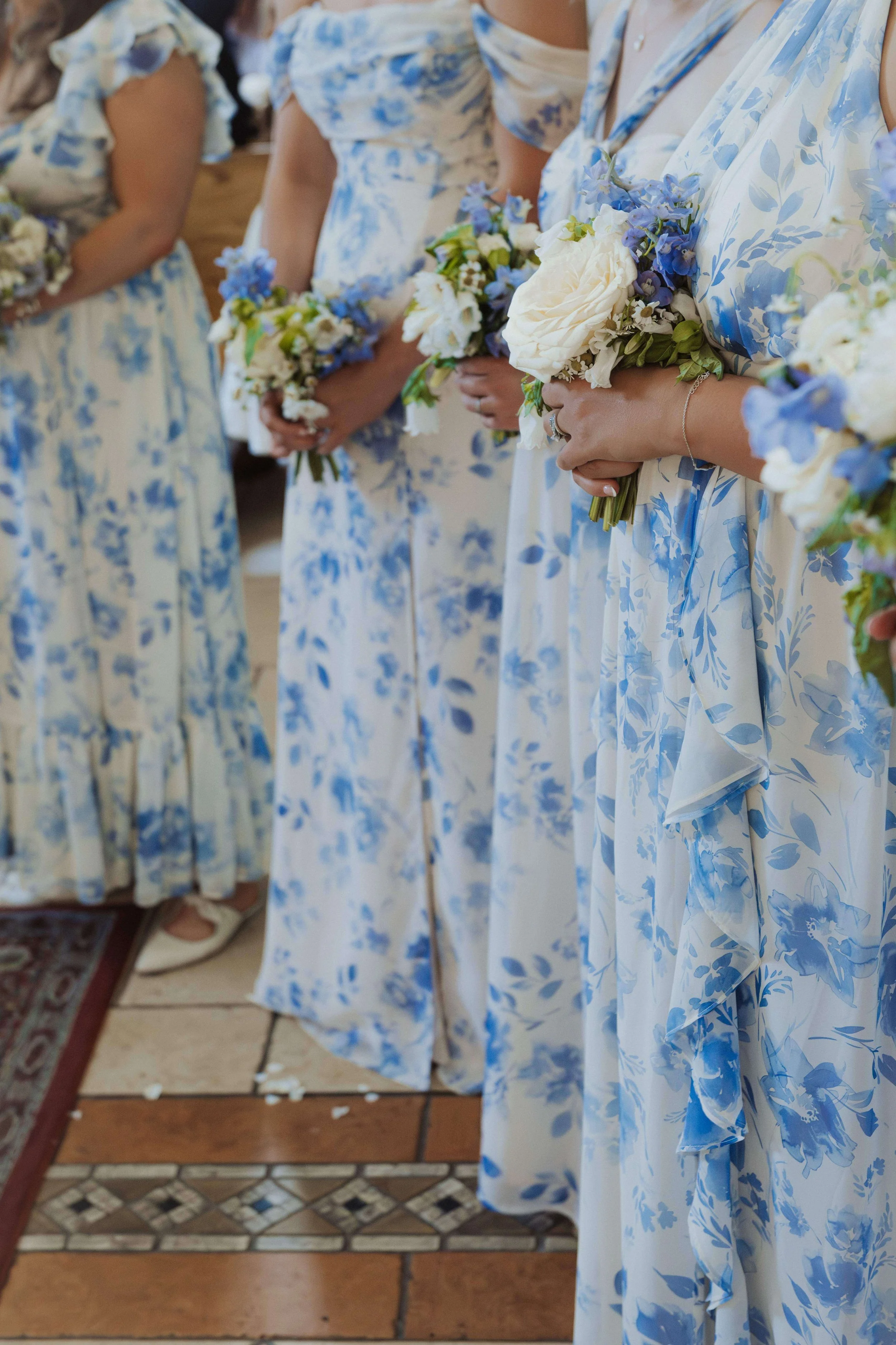 Bridesmaids in matching blue and white floral dresses holding white garden rose and blue delphinium bouquets, Kennebunkport Maine wedding, Milkweed Floral Co