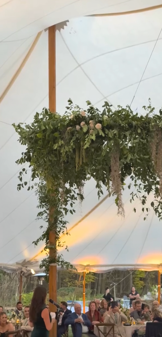 Romantic and cascading hanging installation made of greenery under event tent